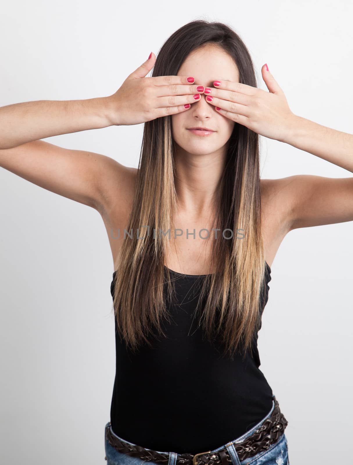 Young caucasian brunette Woman Covers Eyes With Hands by Izaphoto