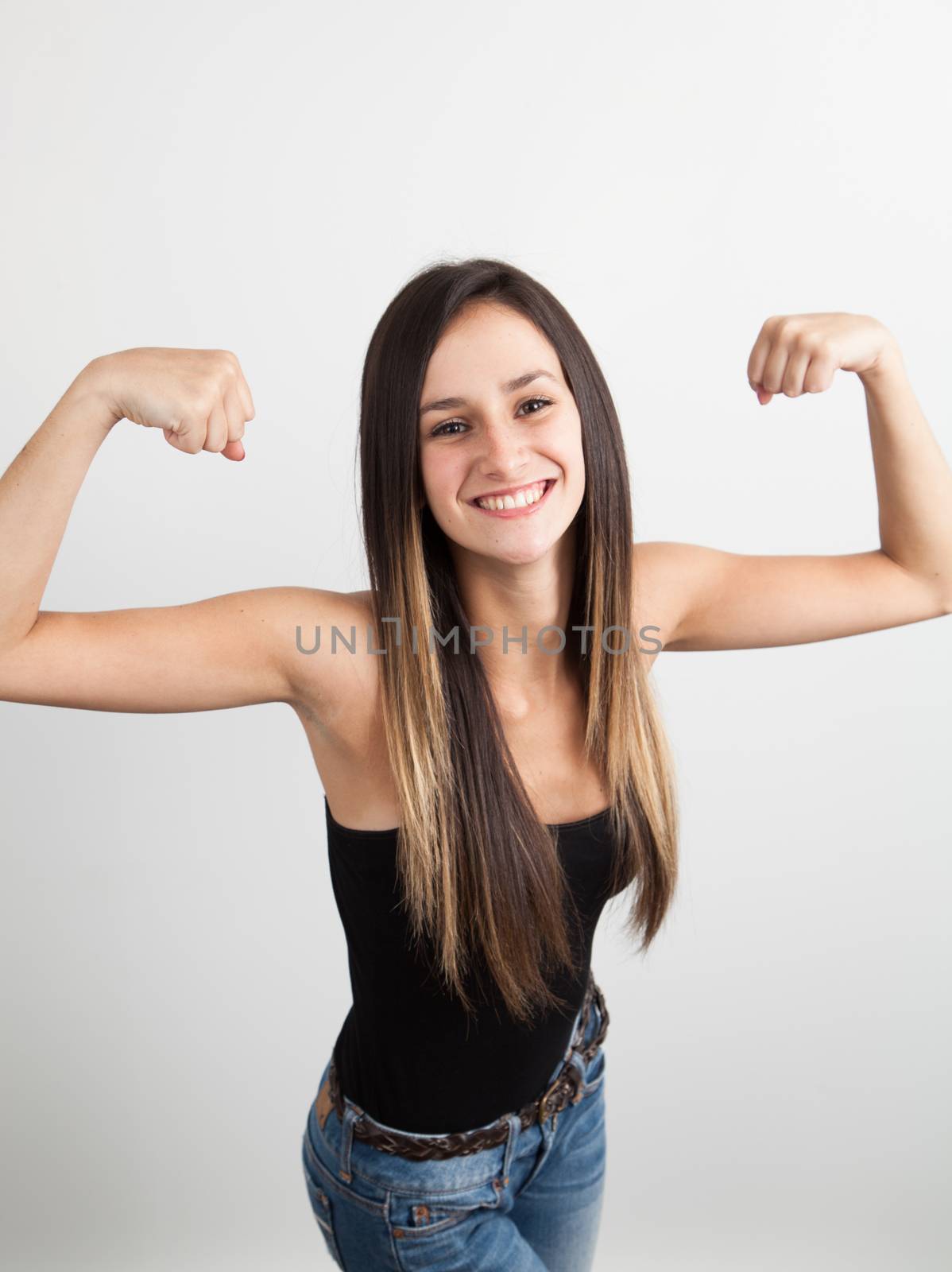 Young brunette woman flexing her biceps by Izaphoto