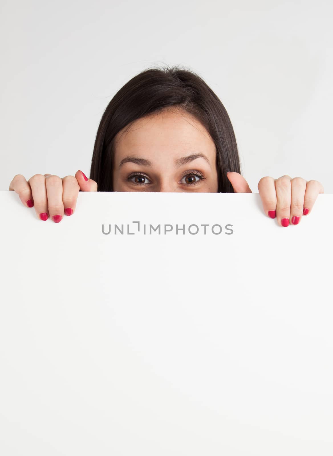 Young brunette caucasian woman holding a blank sign