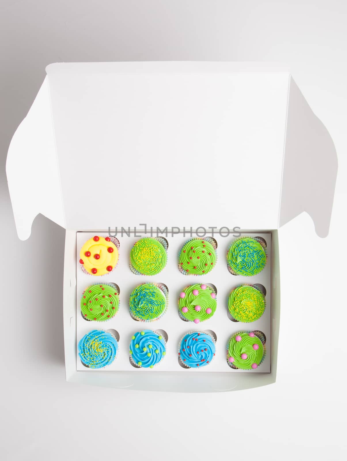 Colorful decorated cupcakes in a white box