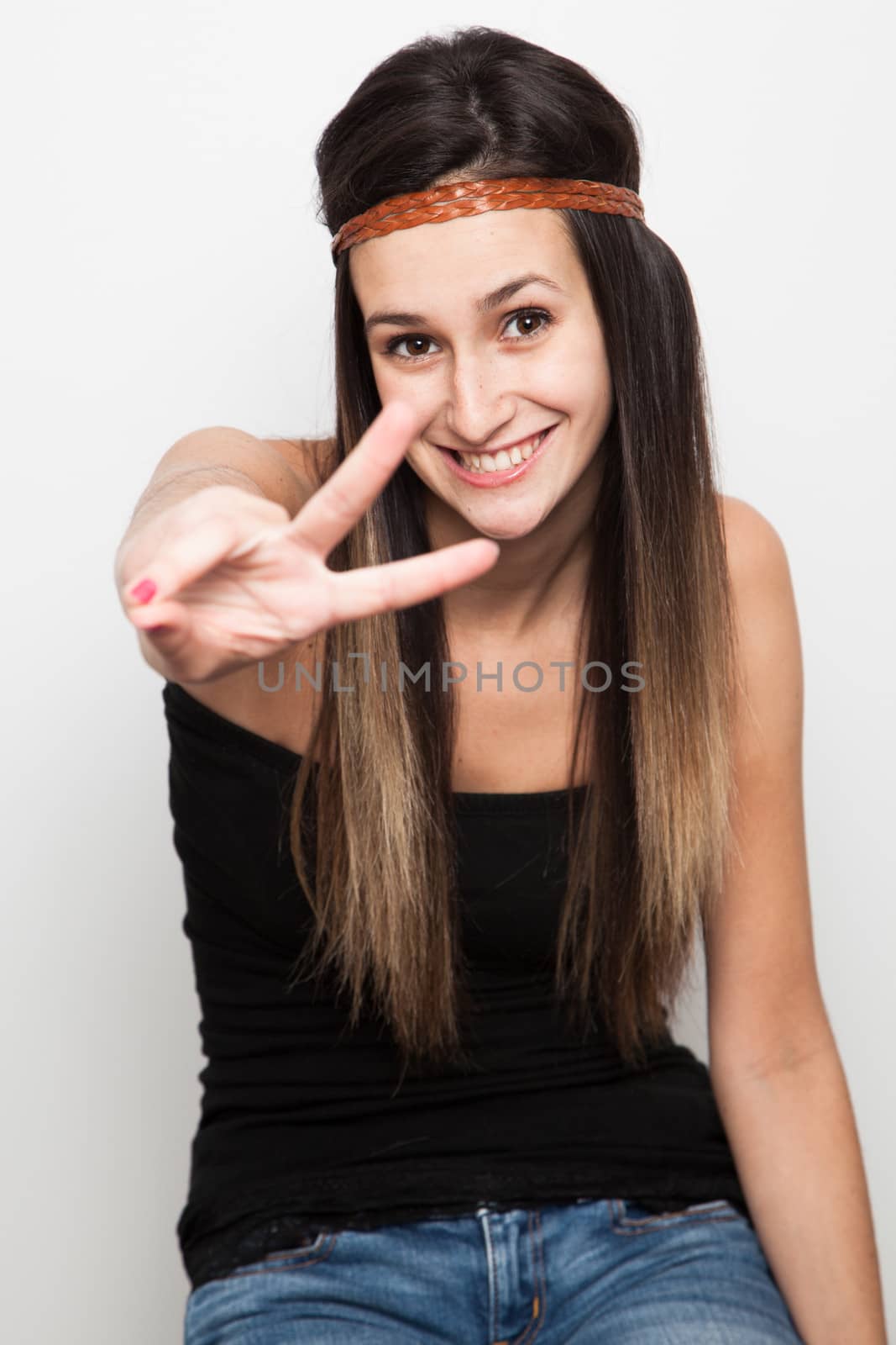 Young caucasian brunette woman doing peace by Izaphoto