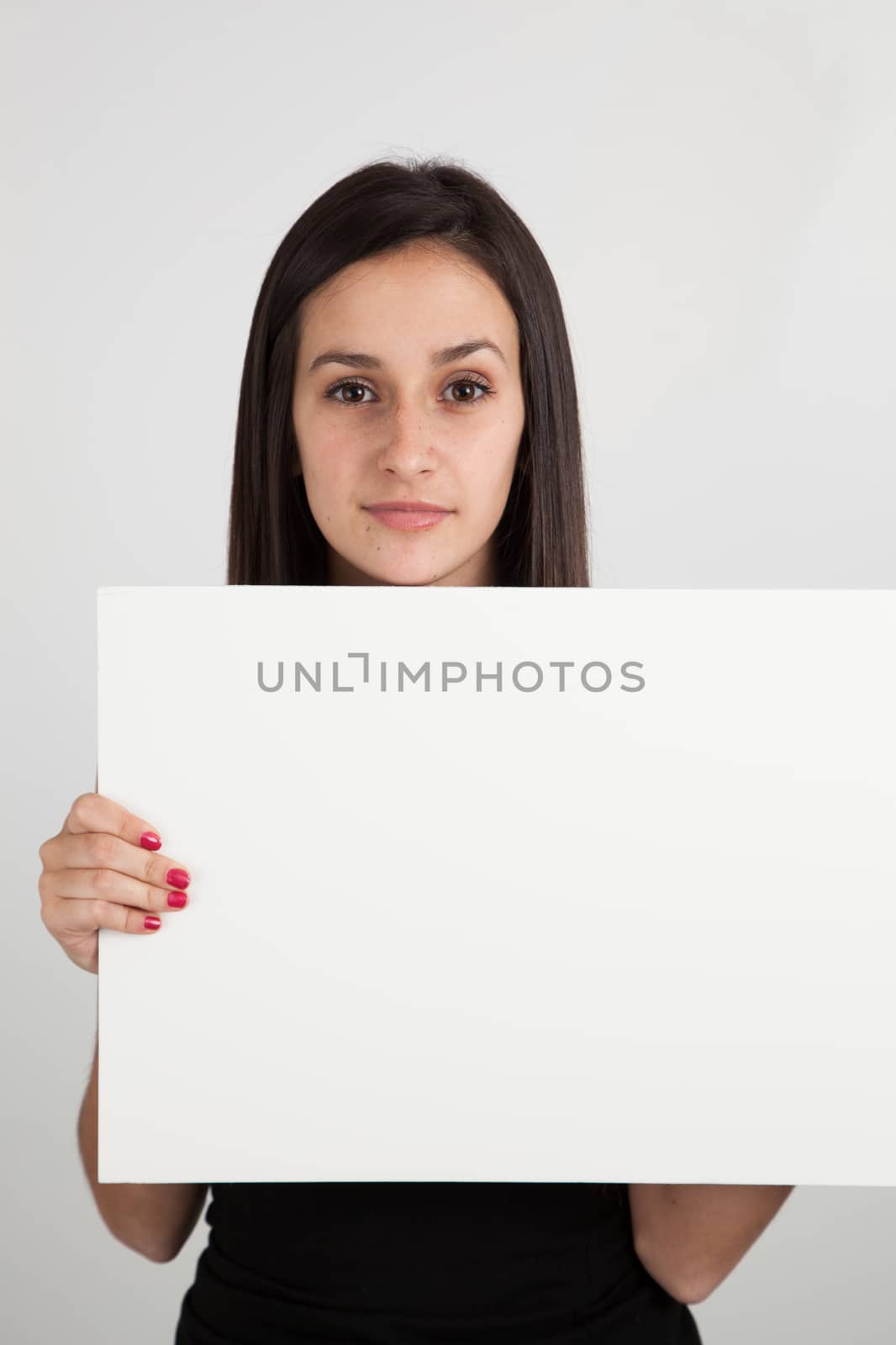 Young brunette woman holding a blank sign by Izaphoto