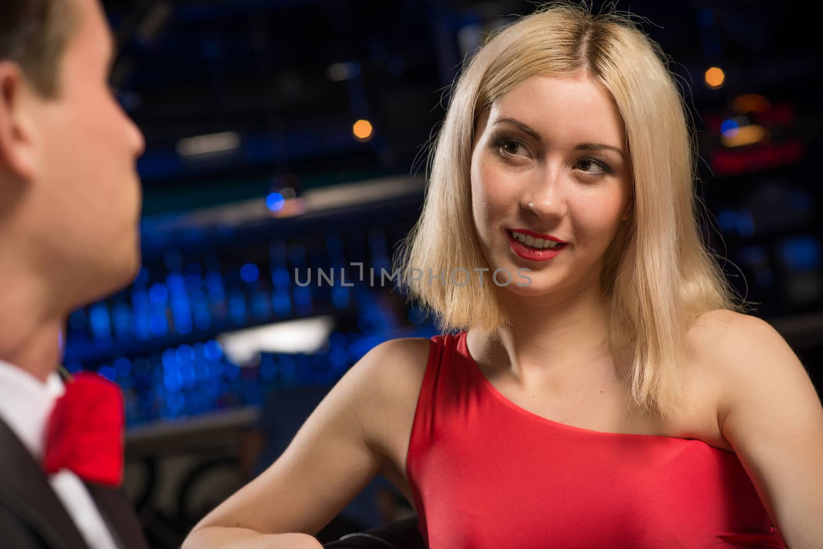 portrait of a woman in a nightclub, sitting on the couch and talking with man