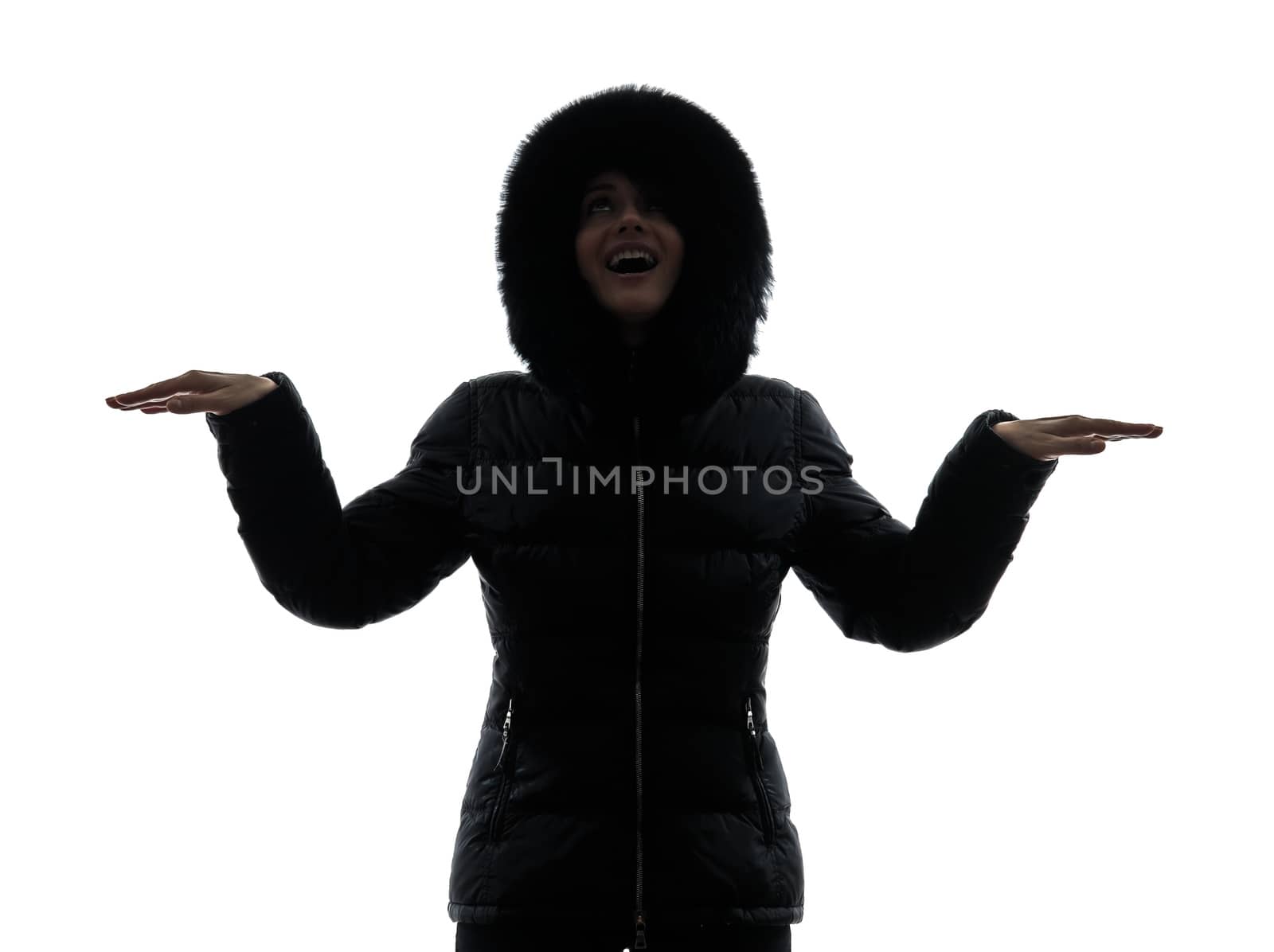 one woman in winter coat arms outstretched happy silhouette on white background