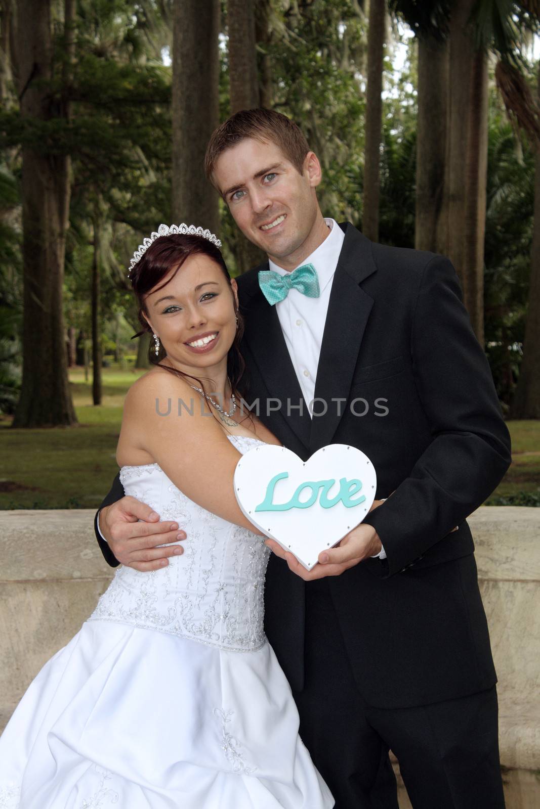 A handsome groom with his beautiful bride outdoors.