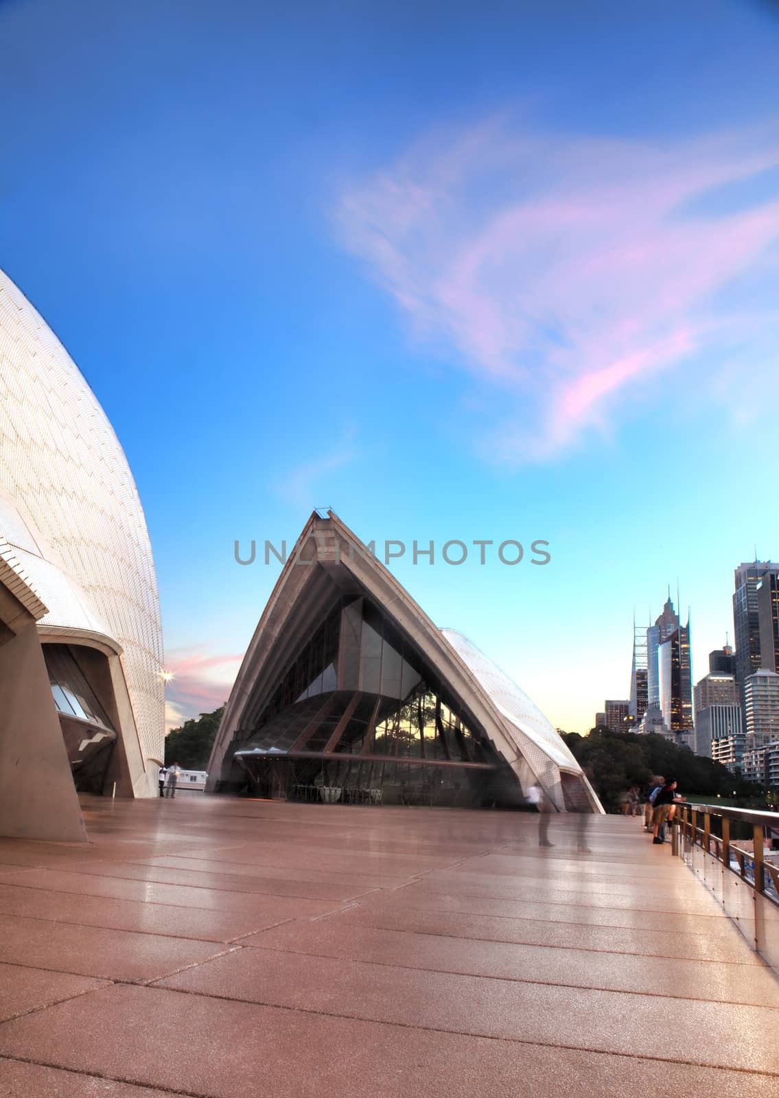 Sydney, Australia - December 2, 2013; Pretty pink clouds in the shape of its sails hang over the Guillaume at Benelong restaurant, Opera House Sydney, Concert Hall to left.
