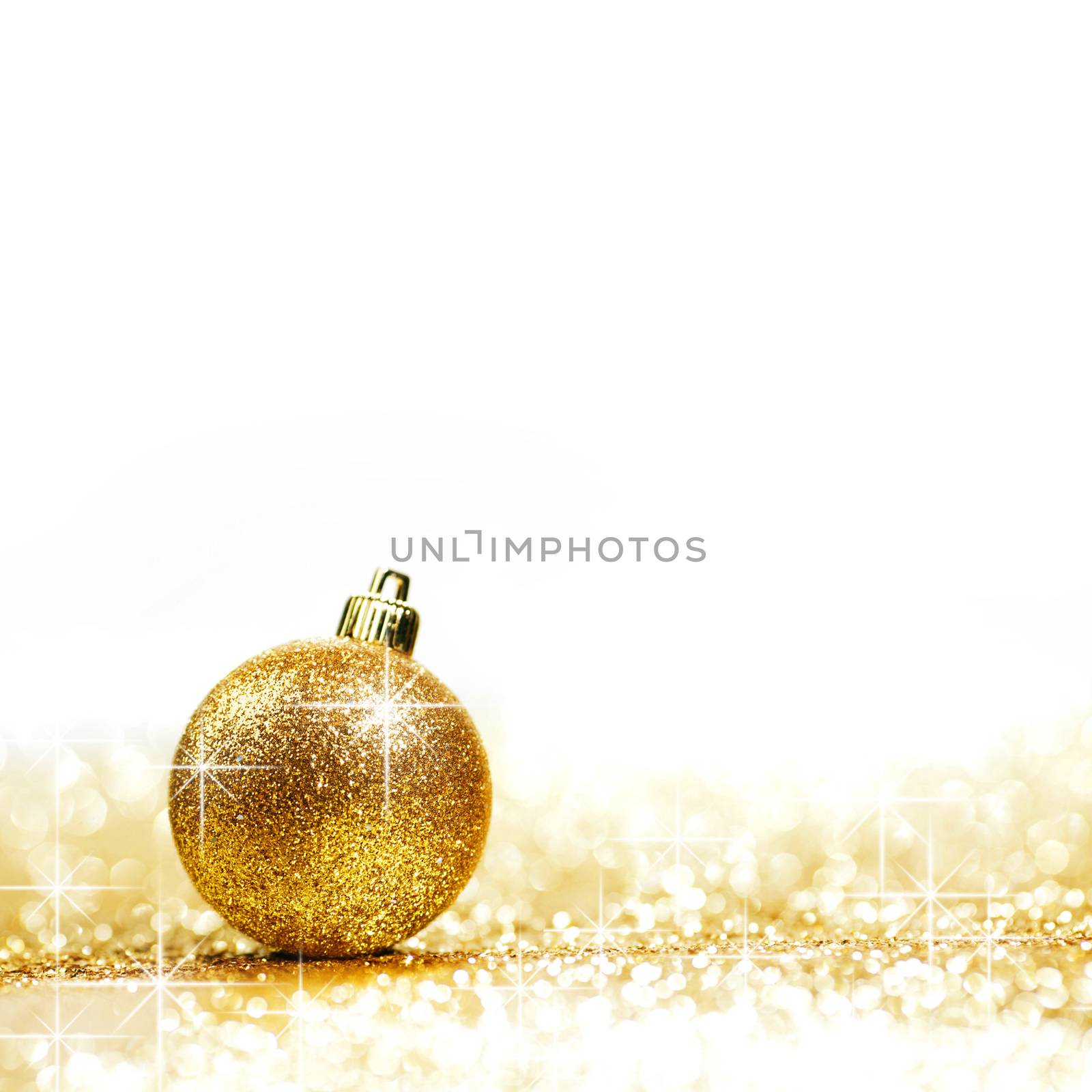 Golden christmas ball on glitter background with white copy space