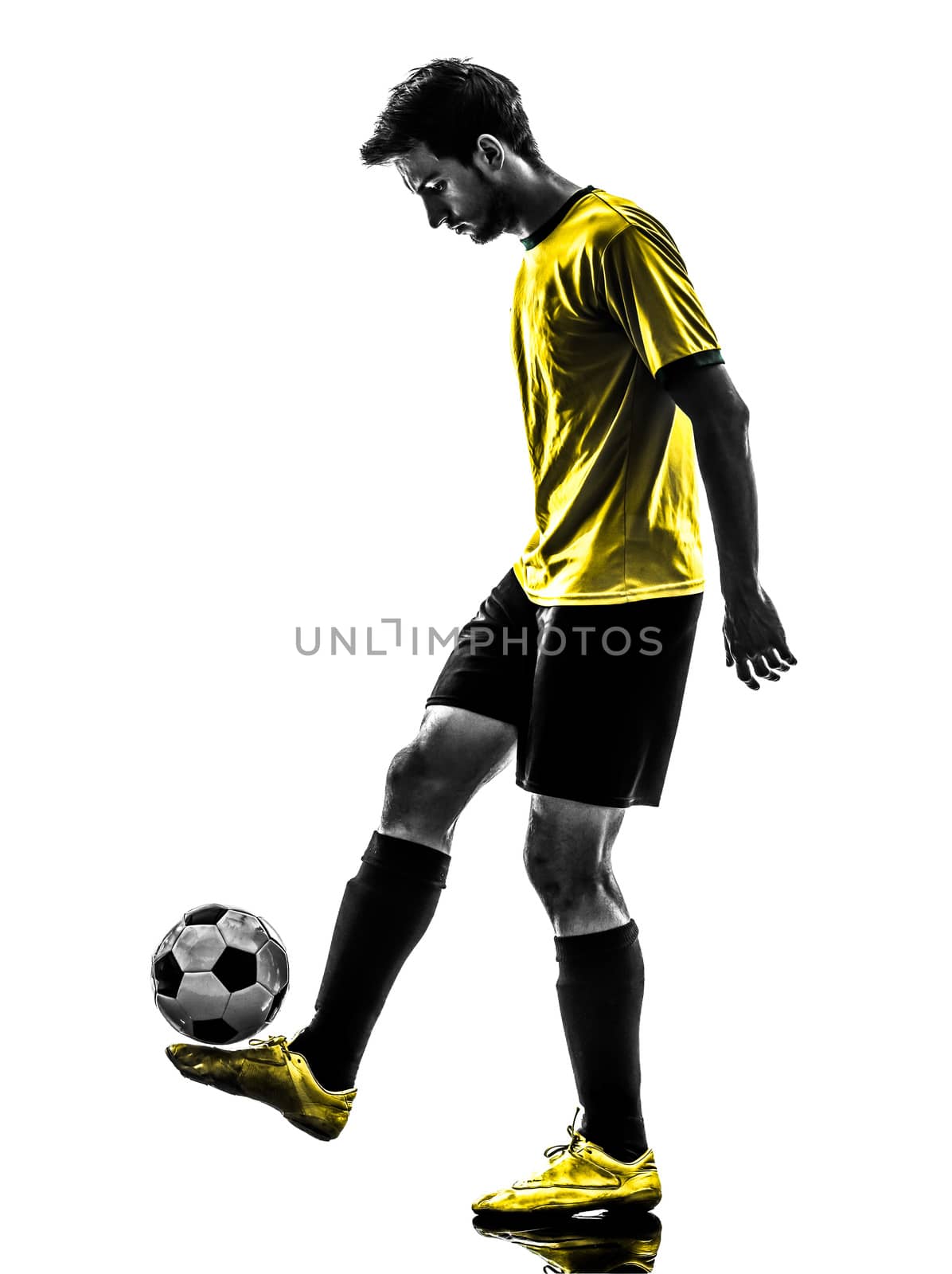 one brazilian soccer football player young man juggling in silhouette studio on white background