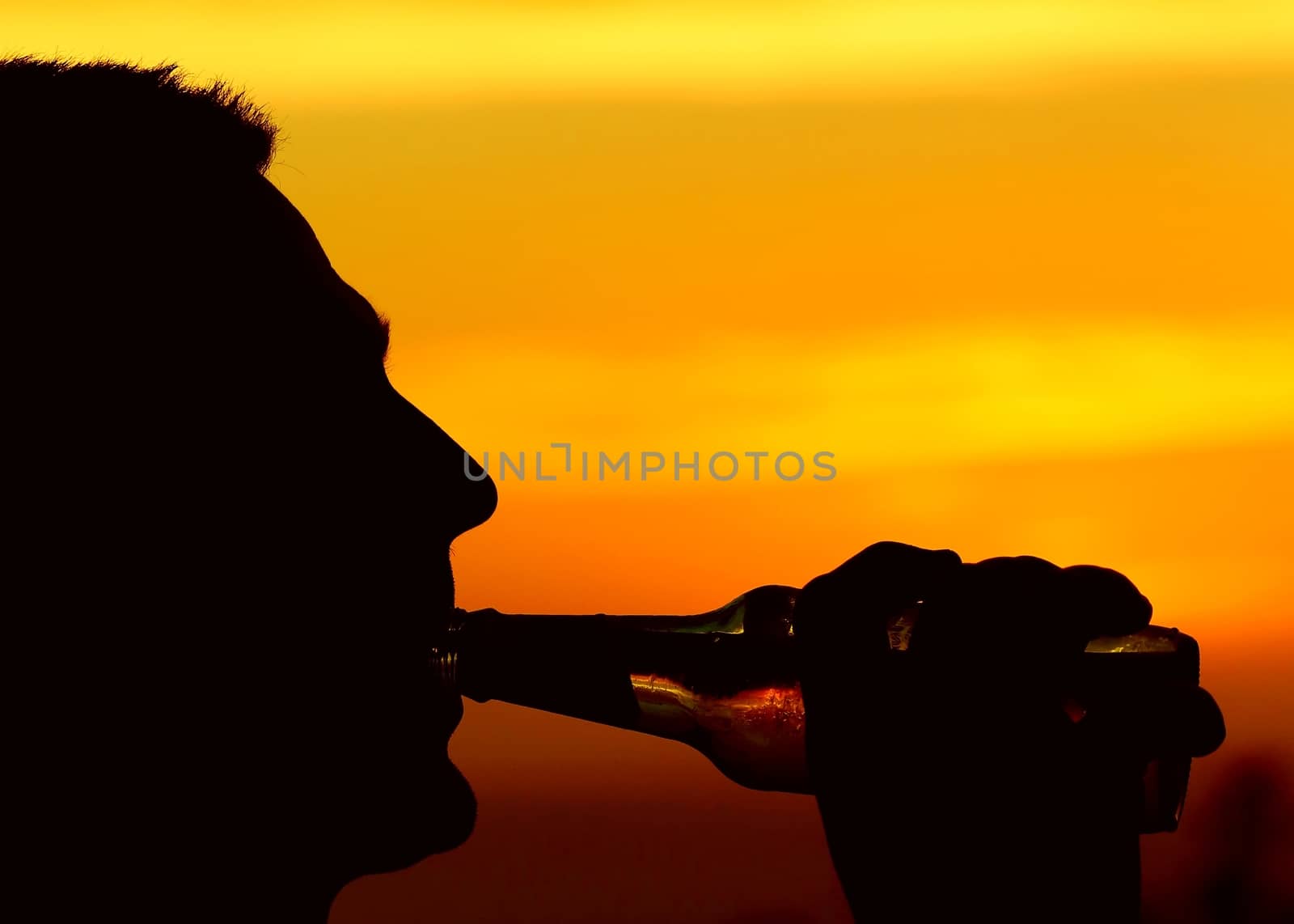 Person enjoying an alcoholic beverage at sun down