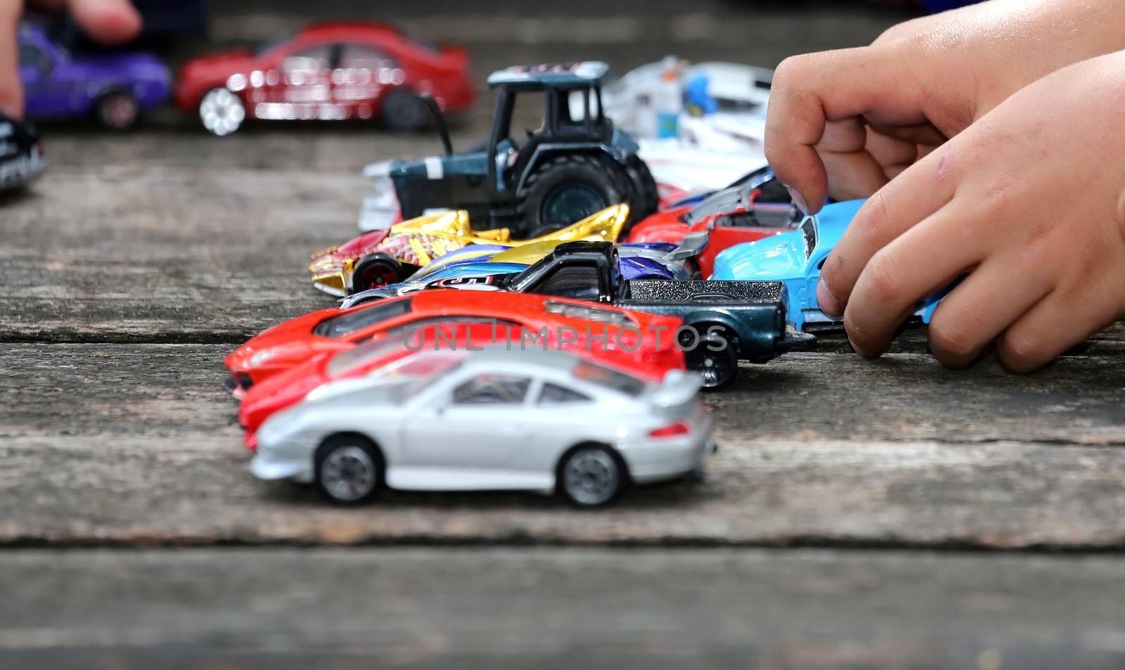 Young boy playing with his big collection of toy cars