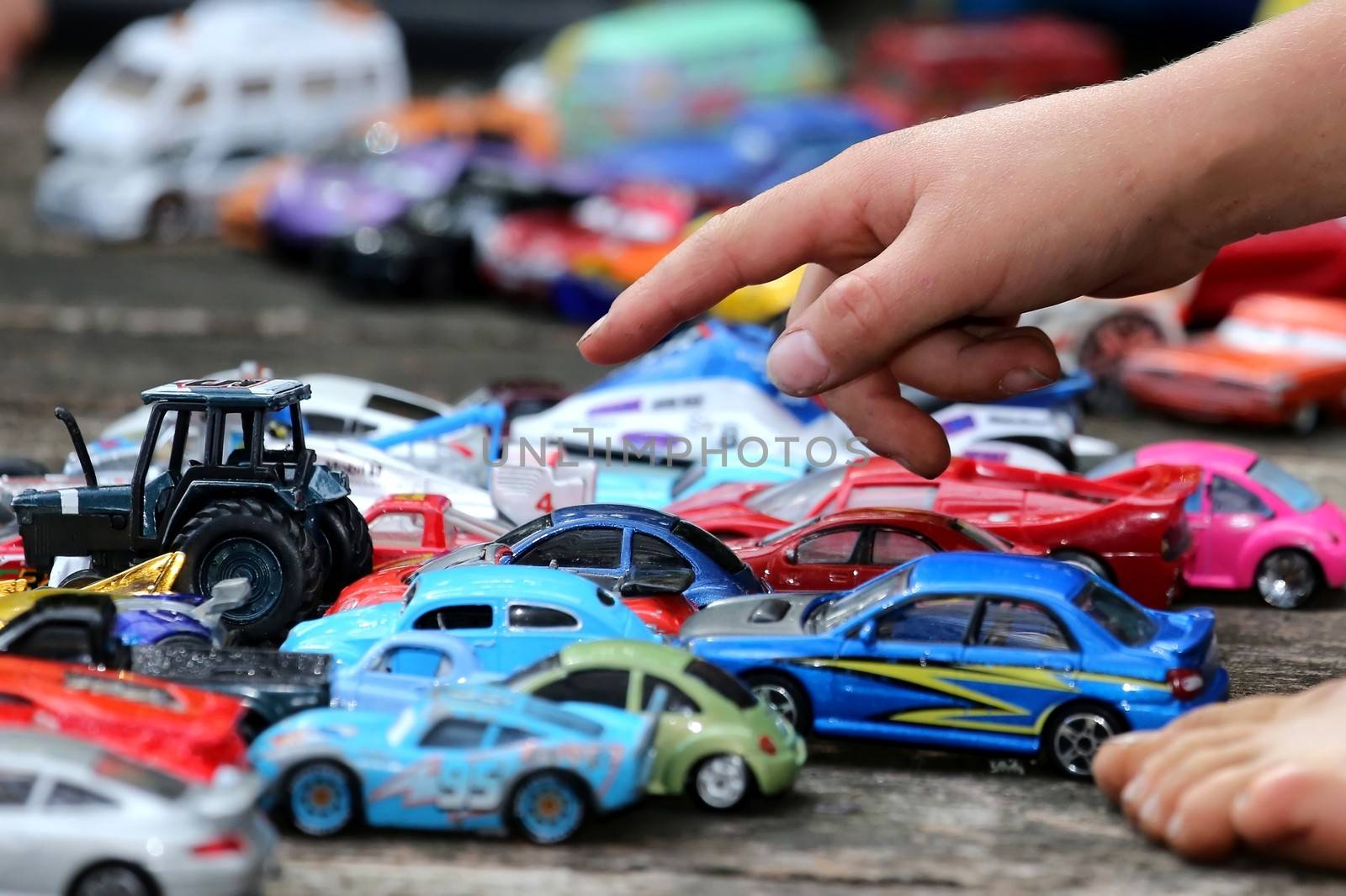 Young boy playing with his big collection of toy cars