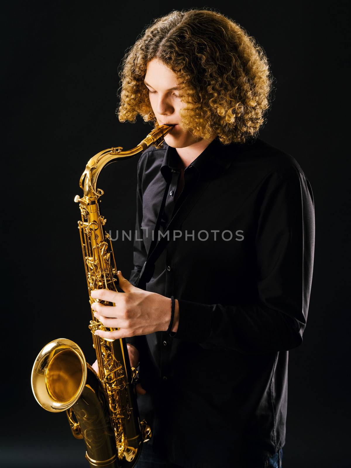 Teenager playing the saxophone by sumners
