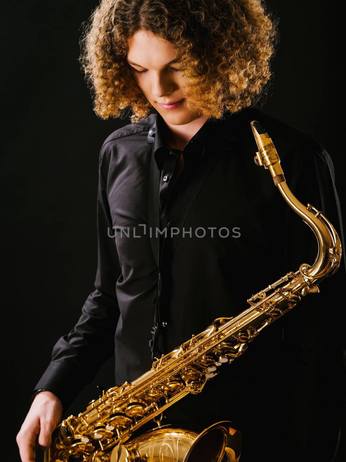Photo of a teenager and his saxophone.