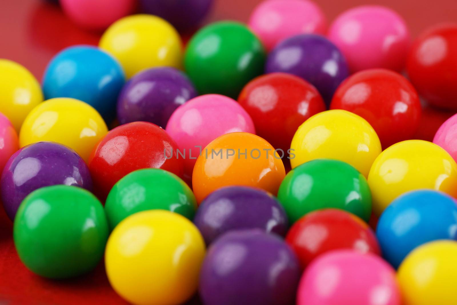 Colorful gumballs with only one orange in the middle