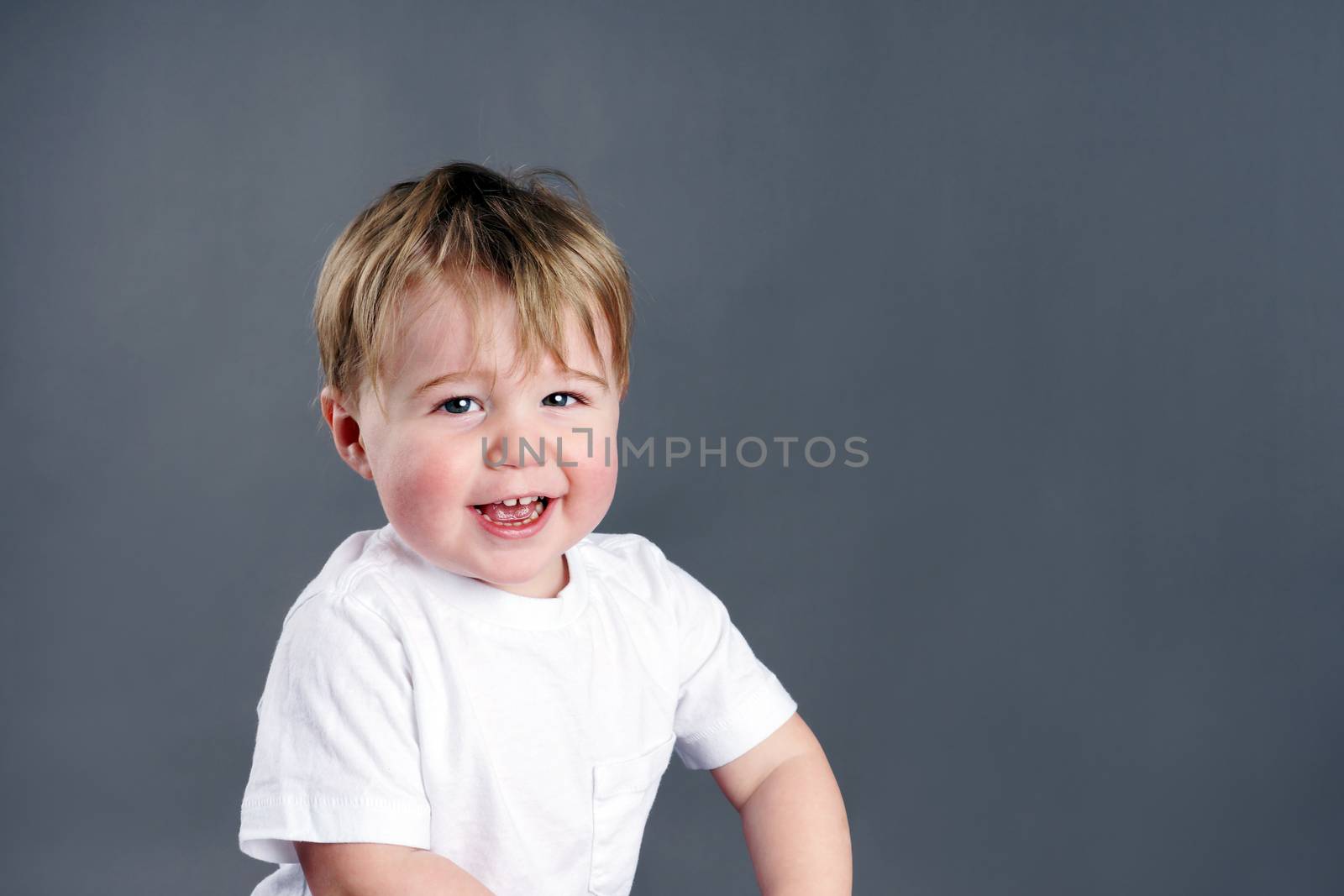 Cute and happy little blond boy or toddler, laughing