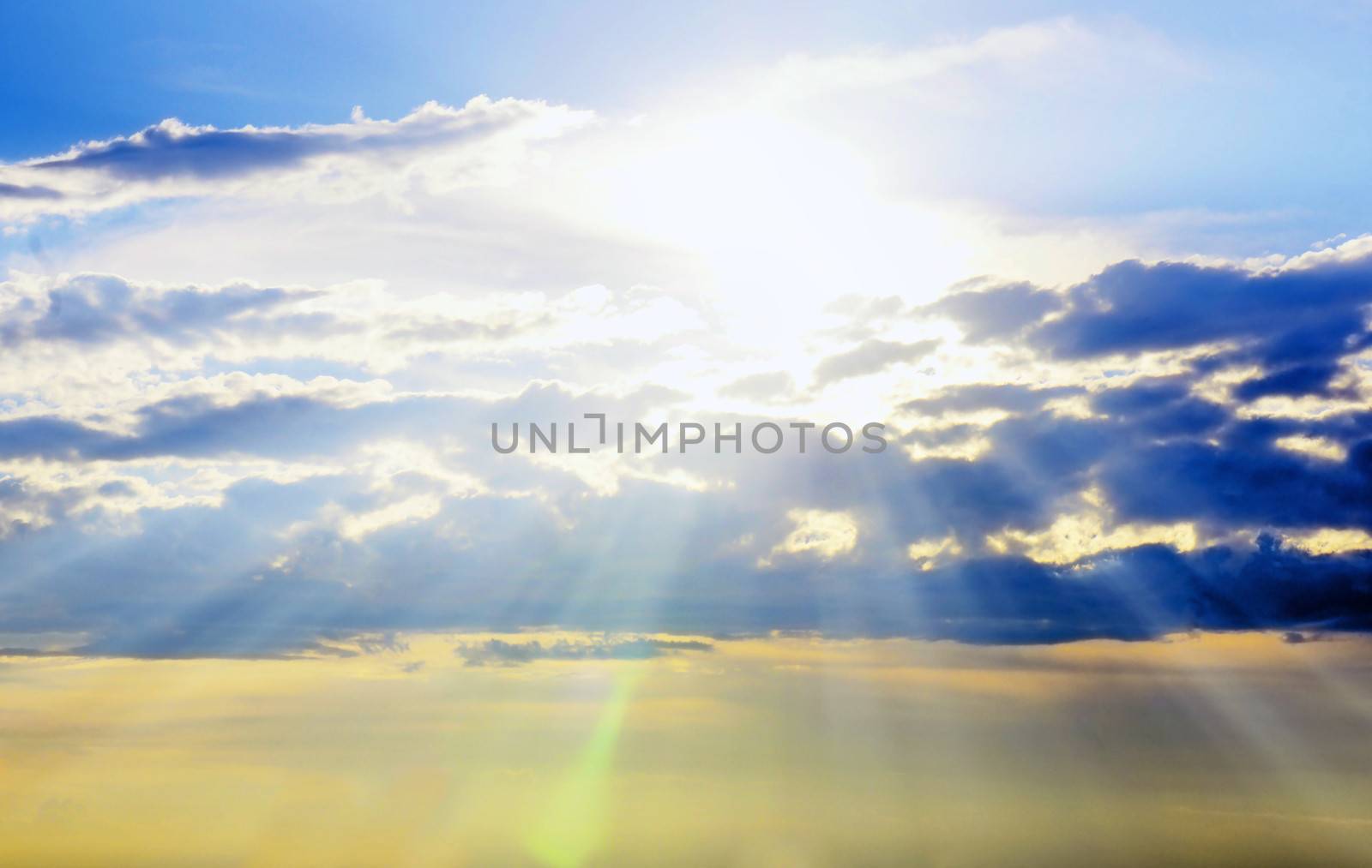Beautiful early sunset sky with sunrays piercing through the clouds with bokeh