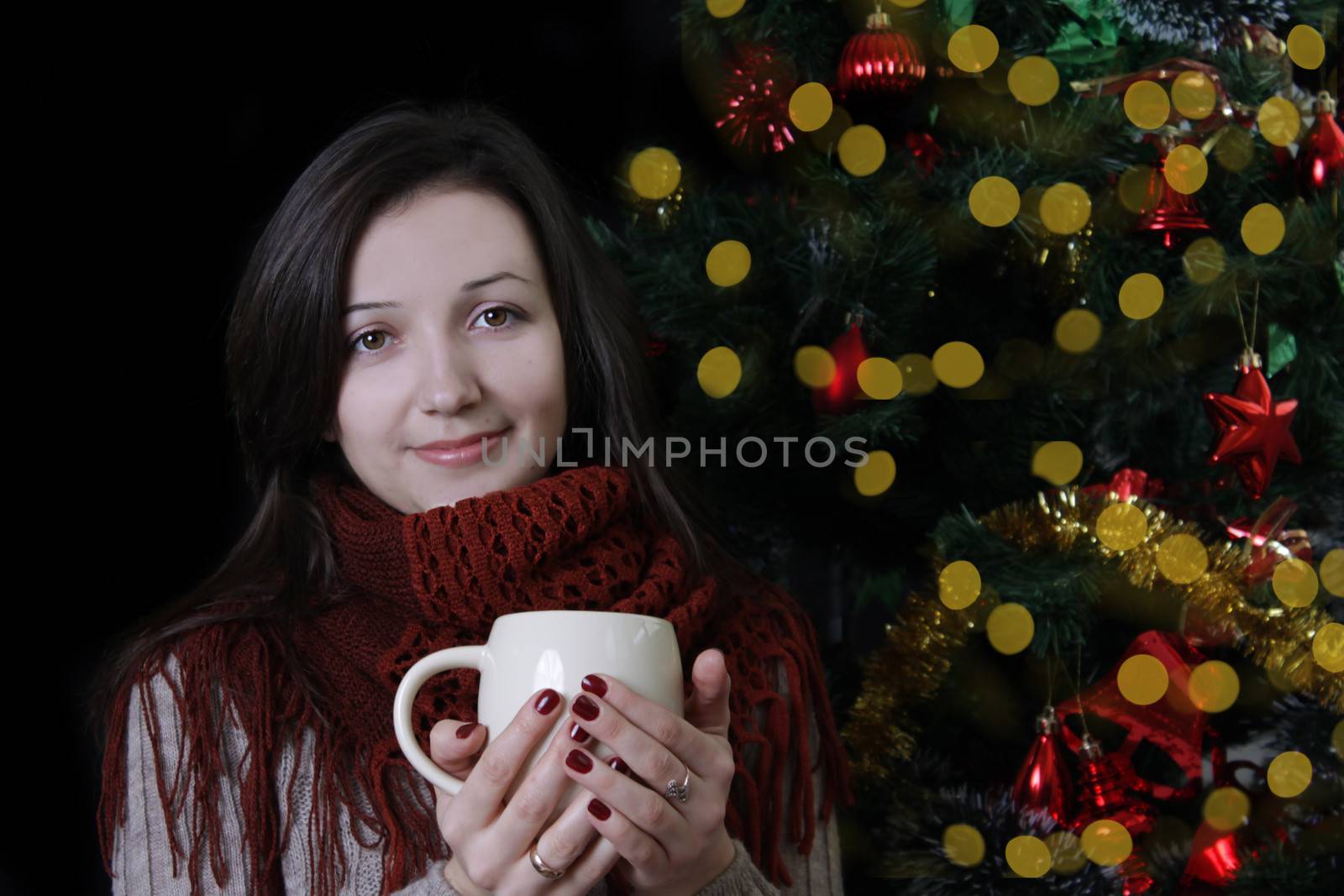 Woman holding mug under Christmas tree on balck by Angel_a