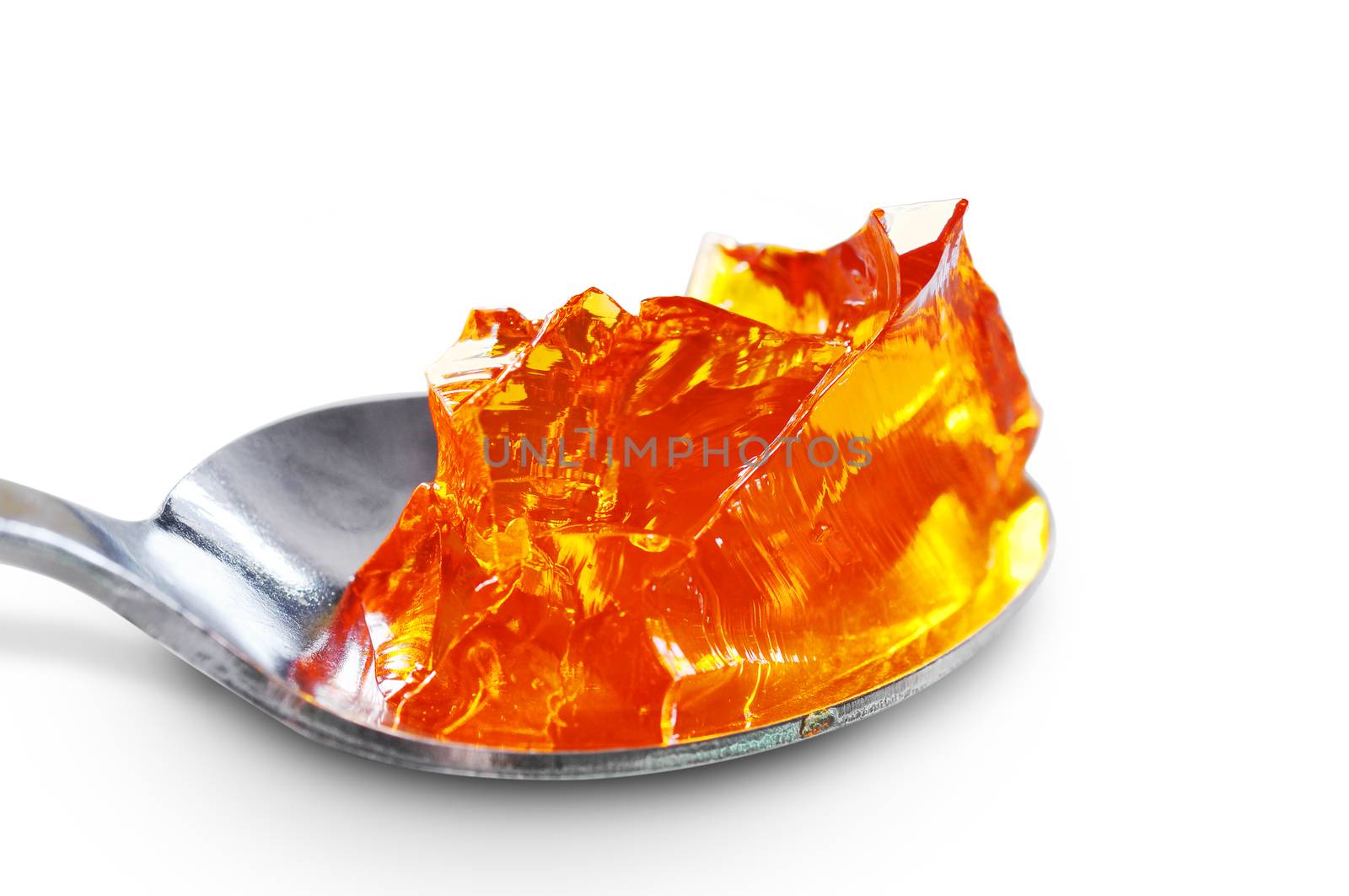 Macro of spoon full of orange jelly or gelatin, on white with shadow