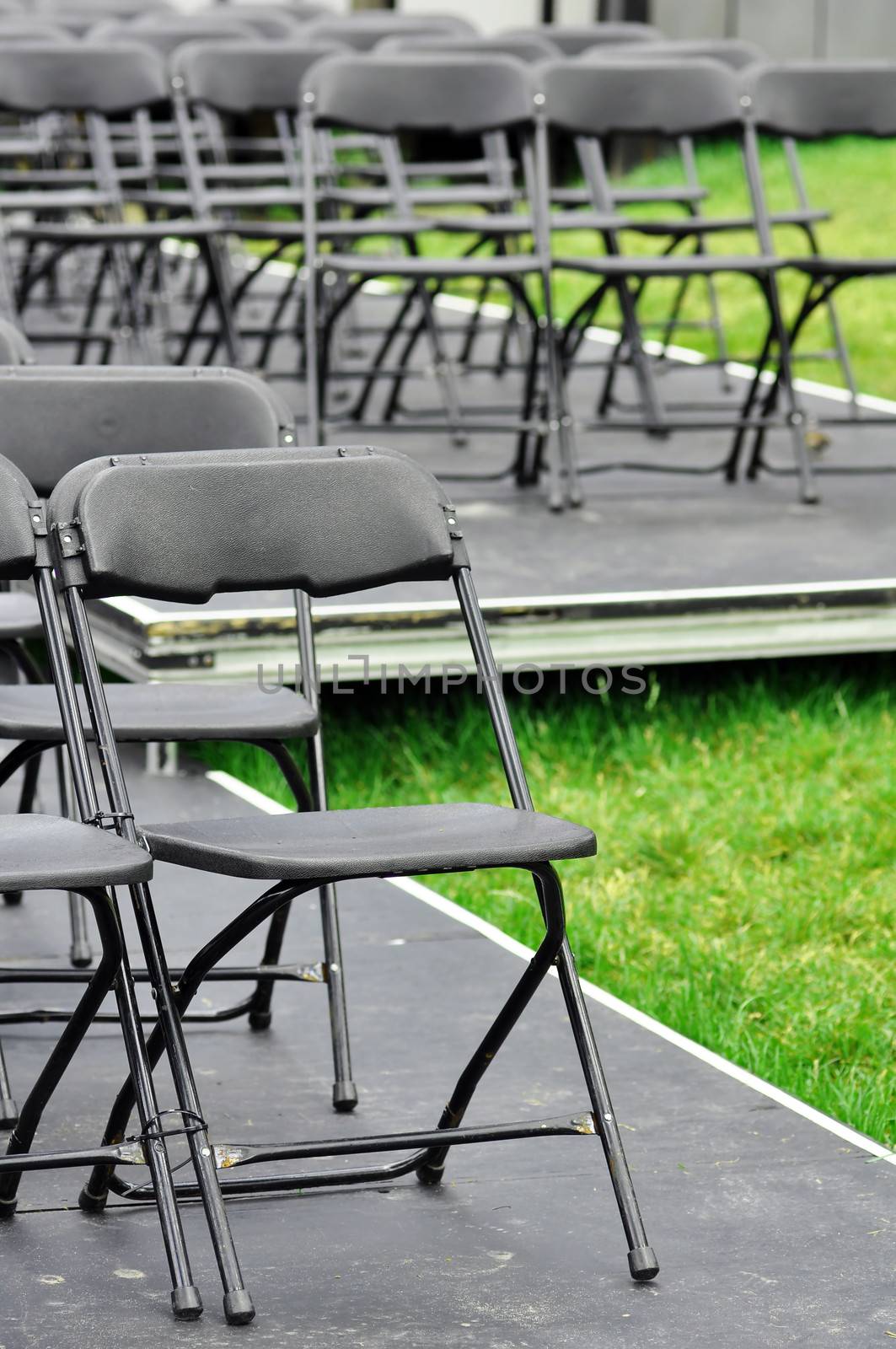 Rows of empty seats ready for outdoor wedding or concert.