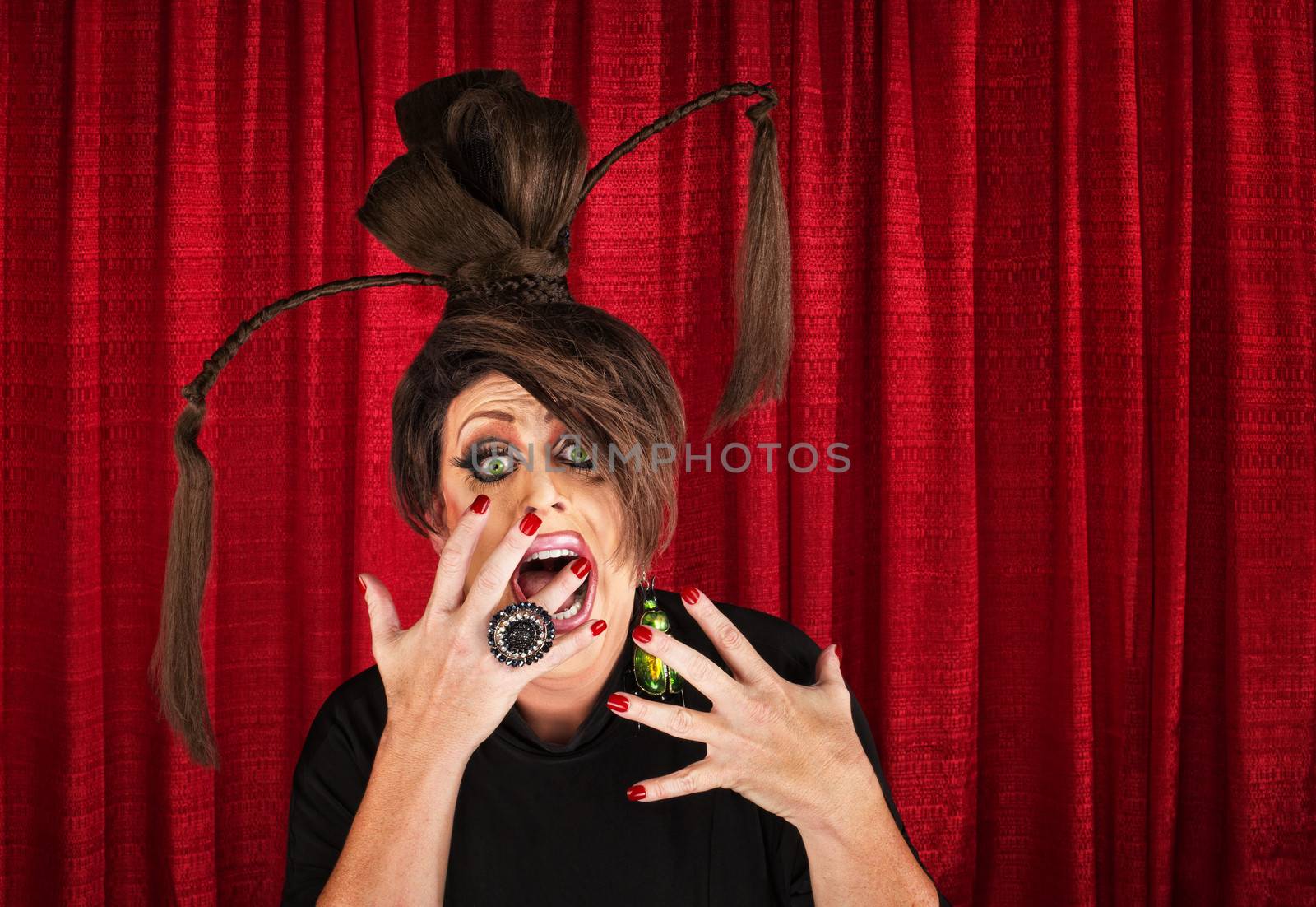 Shouting drag queen with ponytails with hands in front of mouth