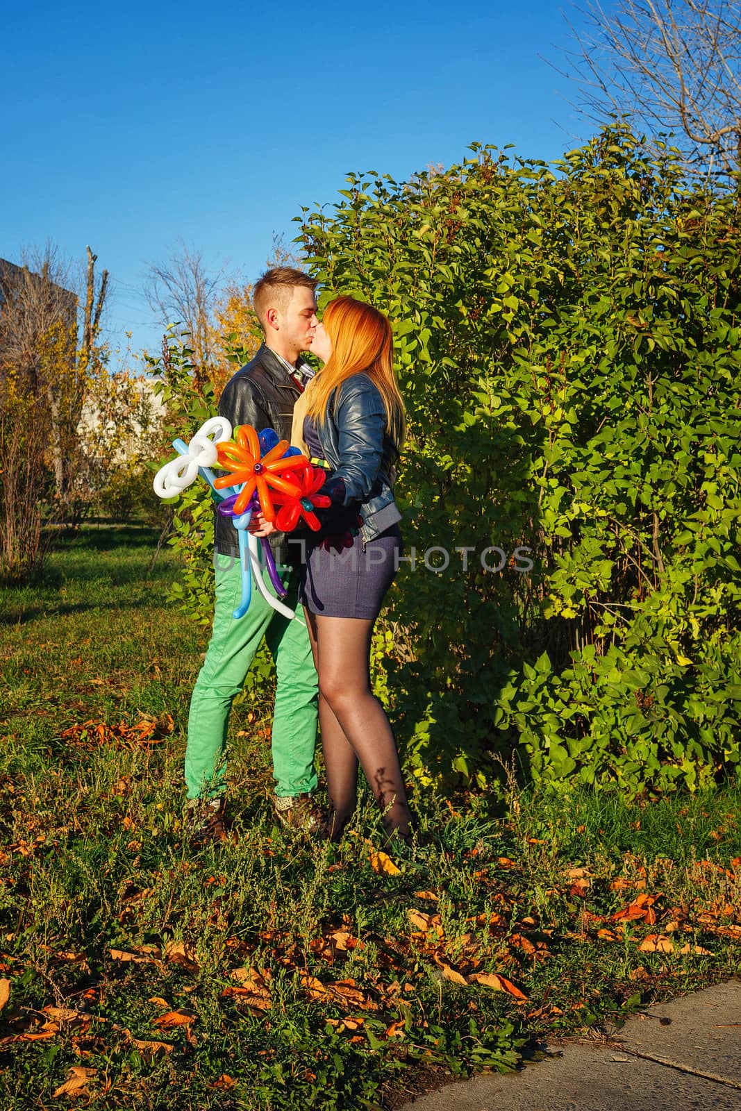 Young couple tenderly and lovingly kiss each other in autumn park