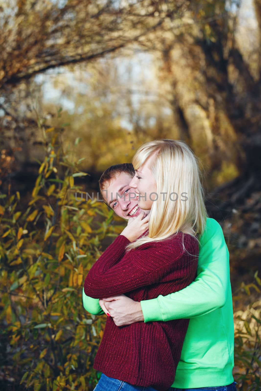 Young couple tenderly and lovingly embrace each other in autumn park