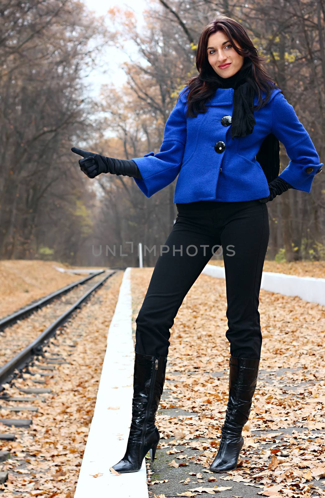 Young woman hitchhiking near the railroad