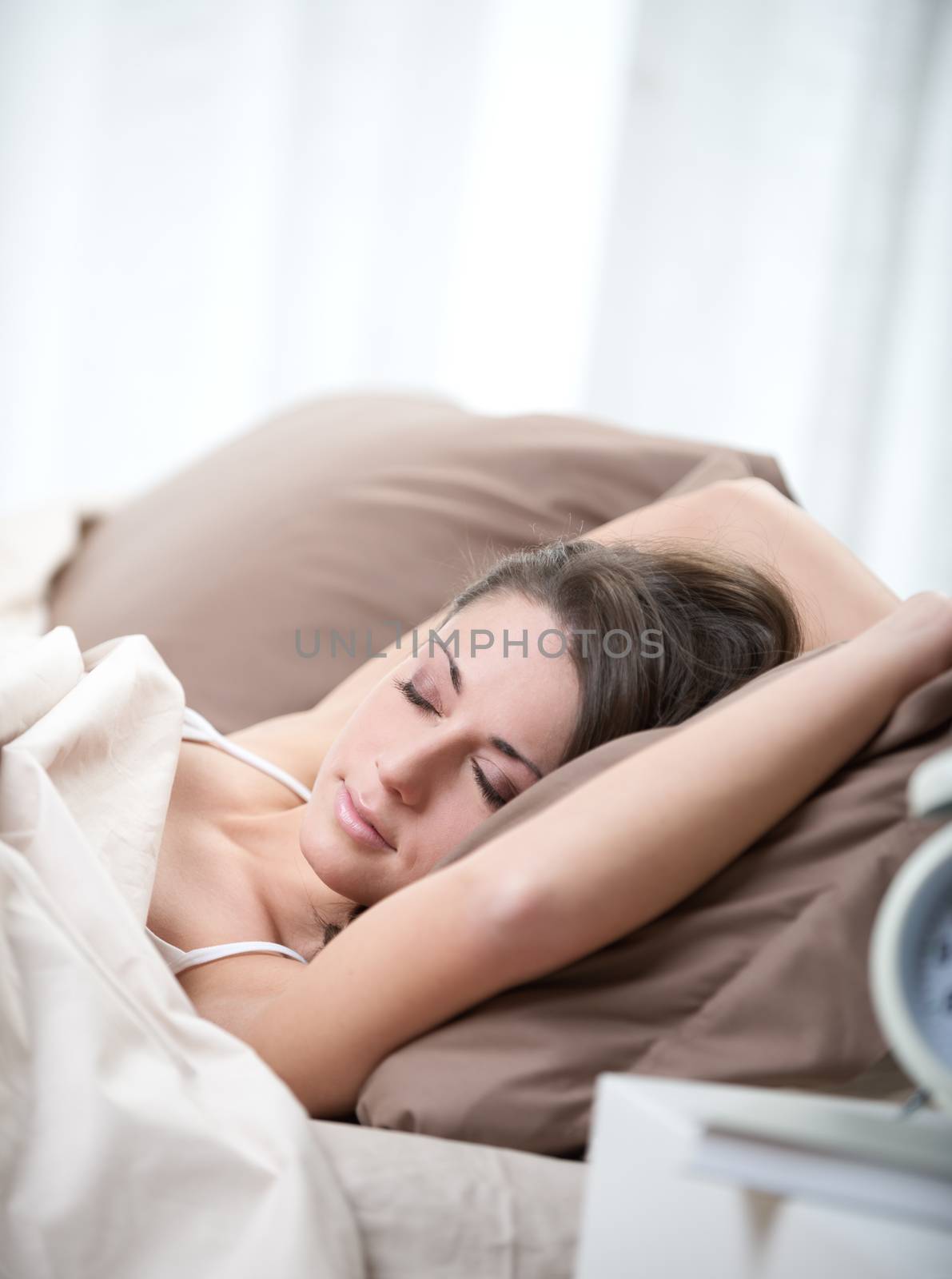 Young beautiful woman sleeping comfortably on bed