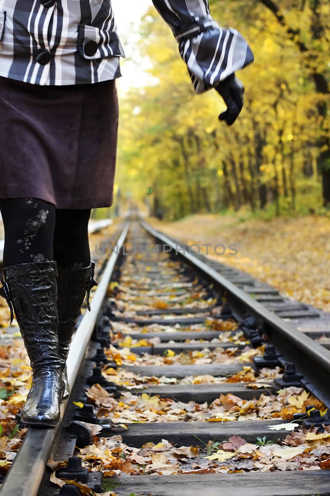 Women walking on rails in a autumn forest