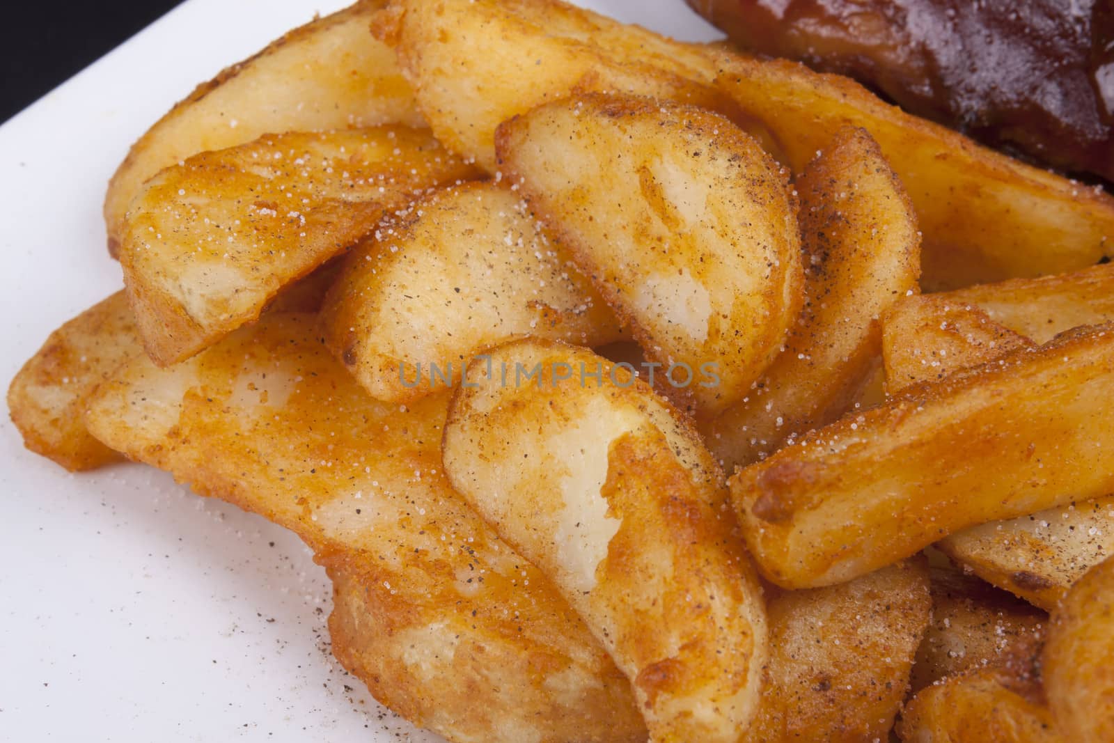 Golden Fried Crisp Potato Wedges on a white plate.