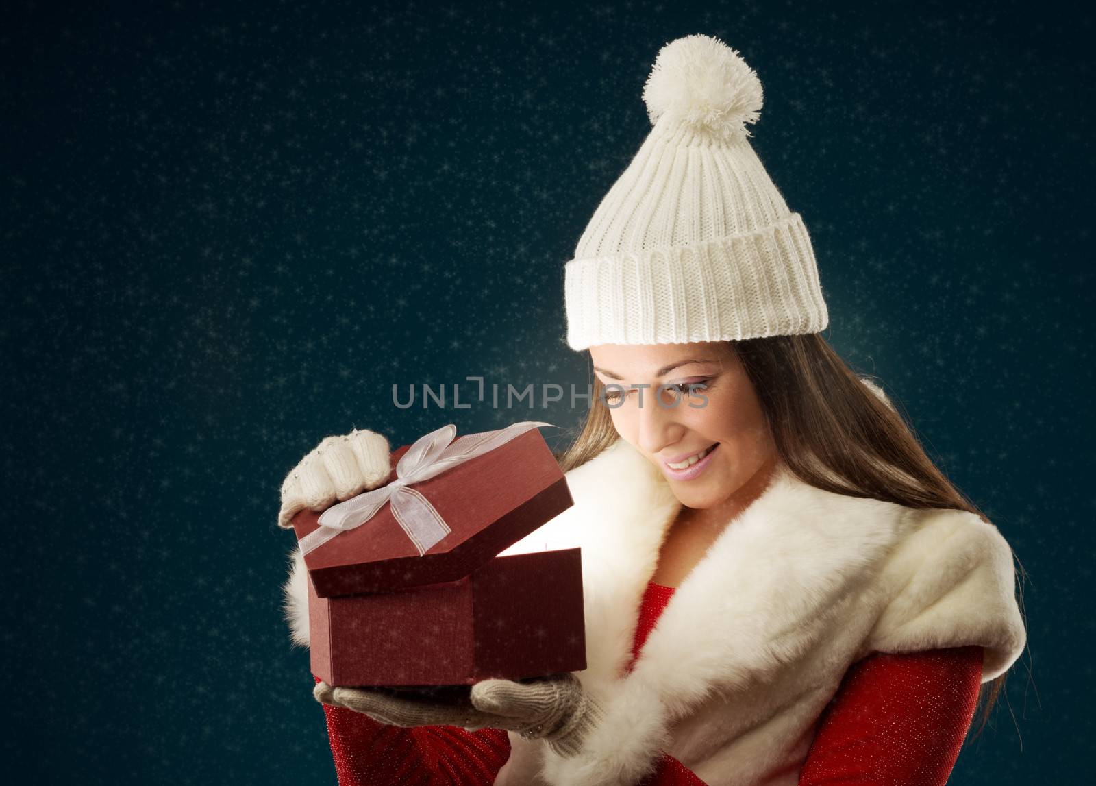 Happy young woman opening Christmas presents, copy space