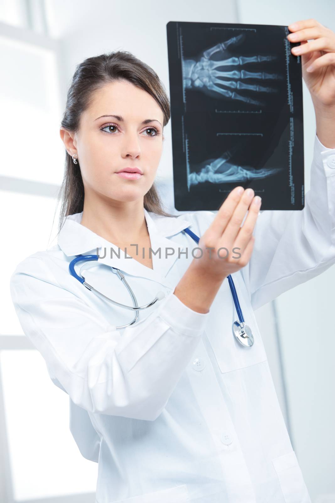 Young woman doctor looking at x-ray photo 