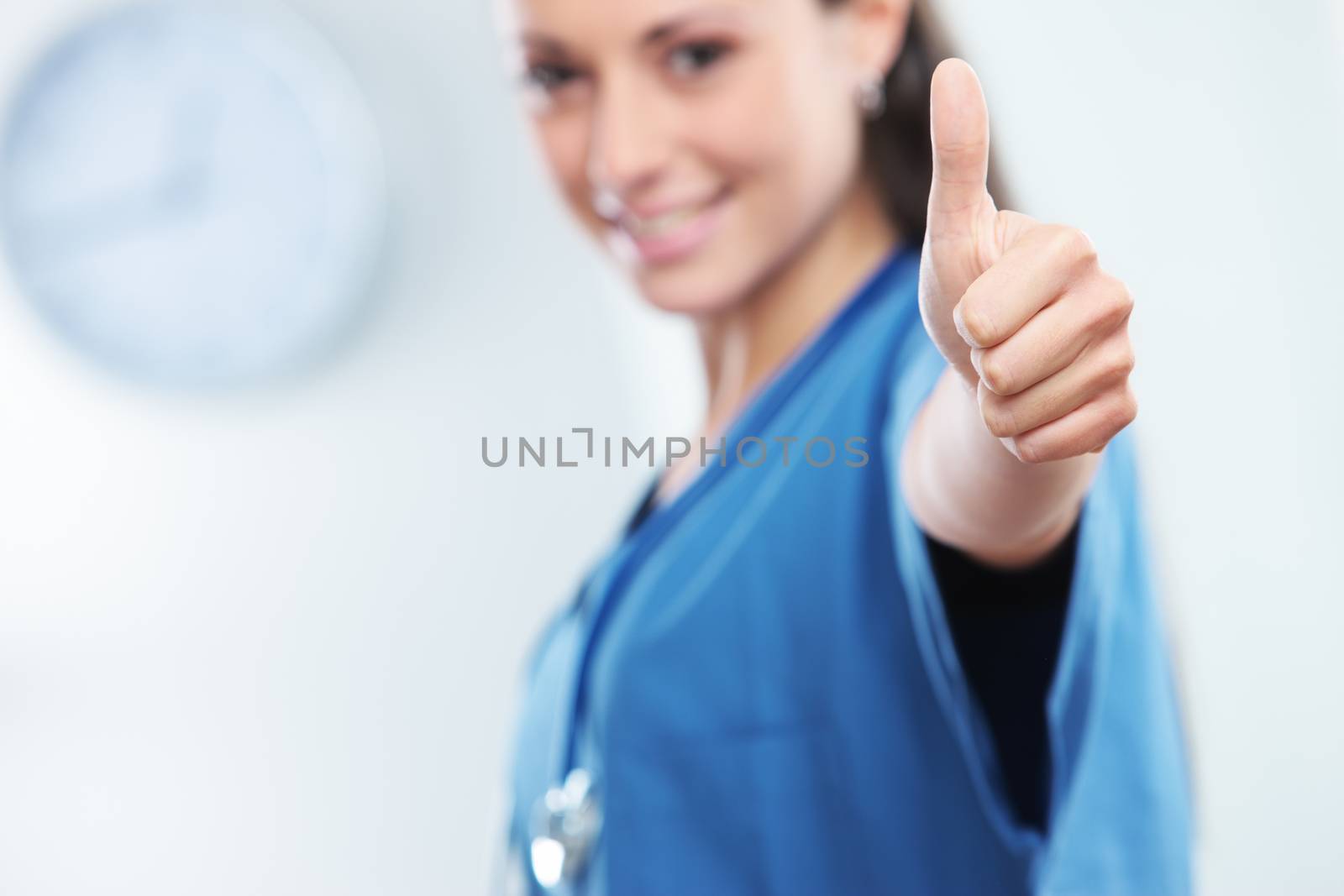Young female doctor gesturing with thumbs up