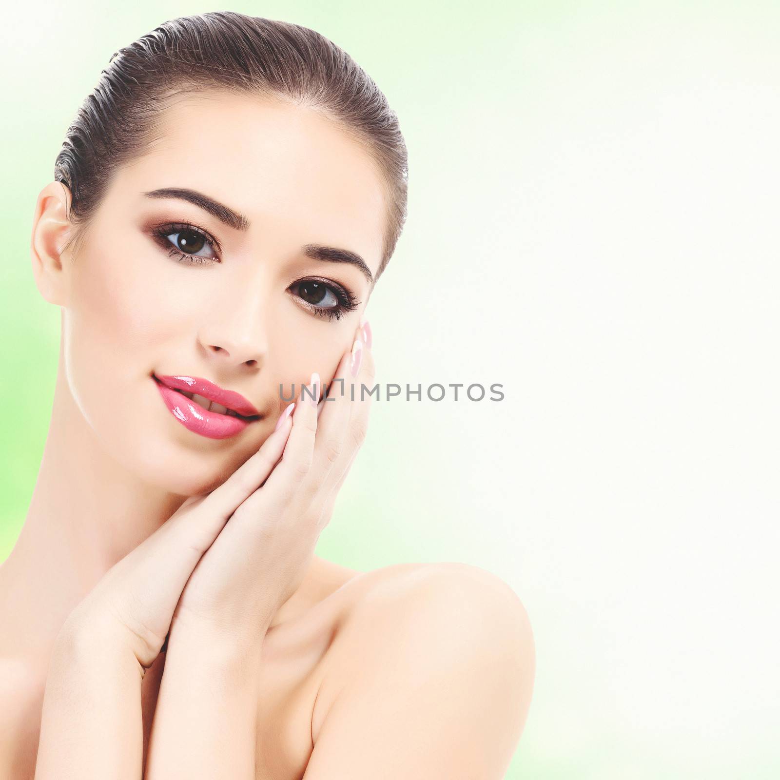 Beautiful girl with clean fresh skin, abstract green blurred background with copyspace