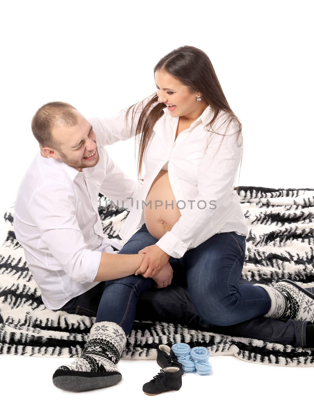 Man and pregnant woman on blanket. by indigolotos