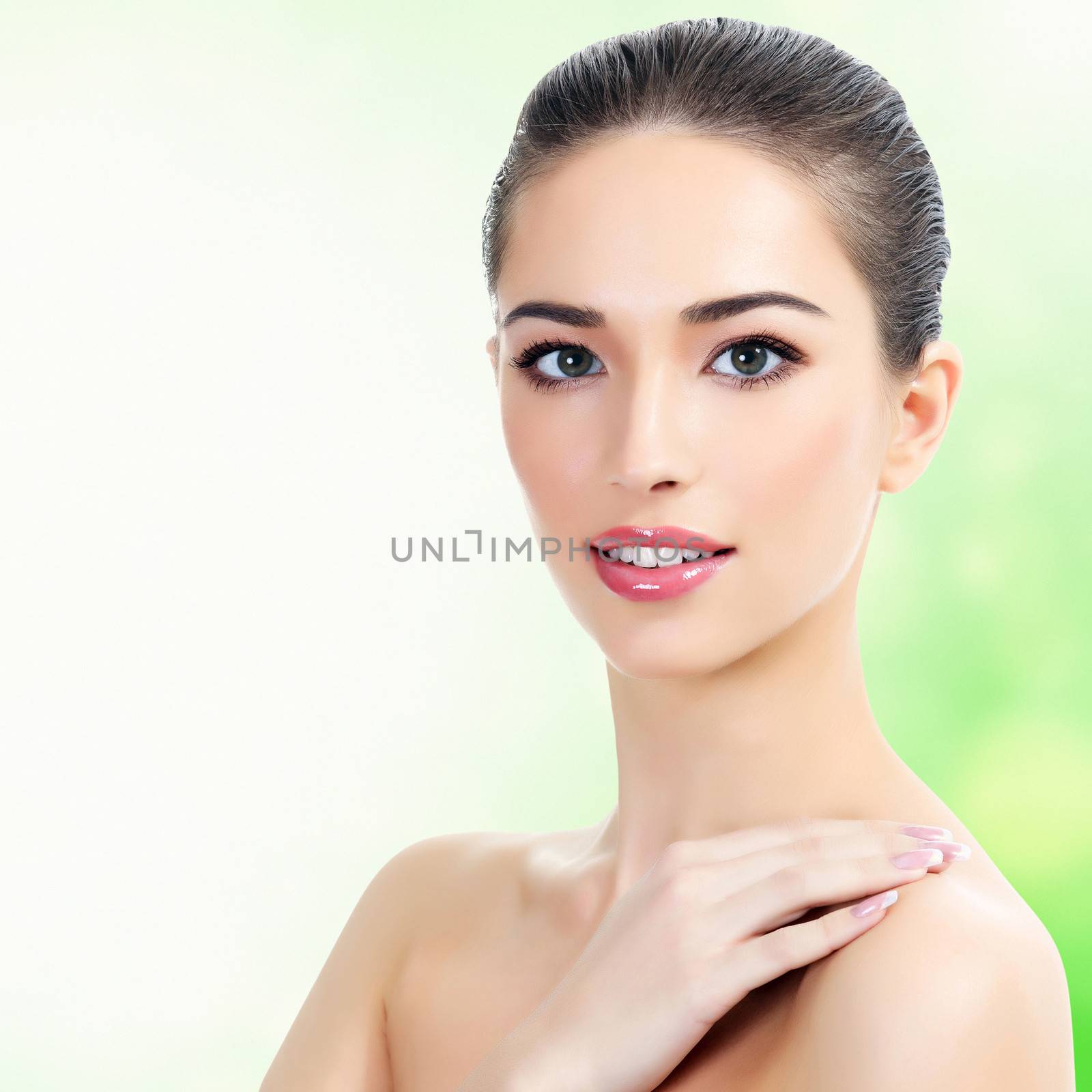 Beautiful girl with clean fresh skin, abstract green blurred background with copyspace