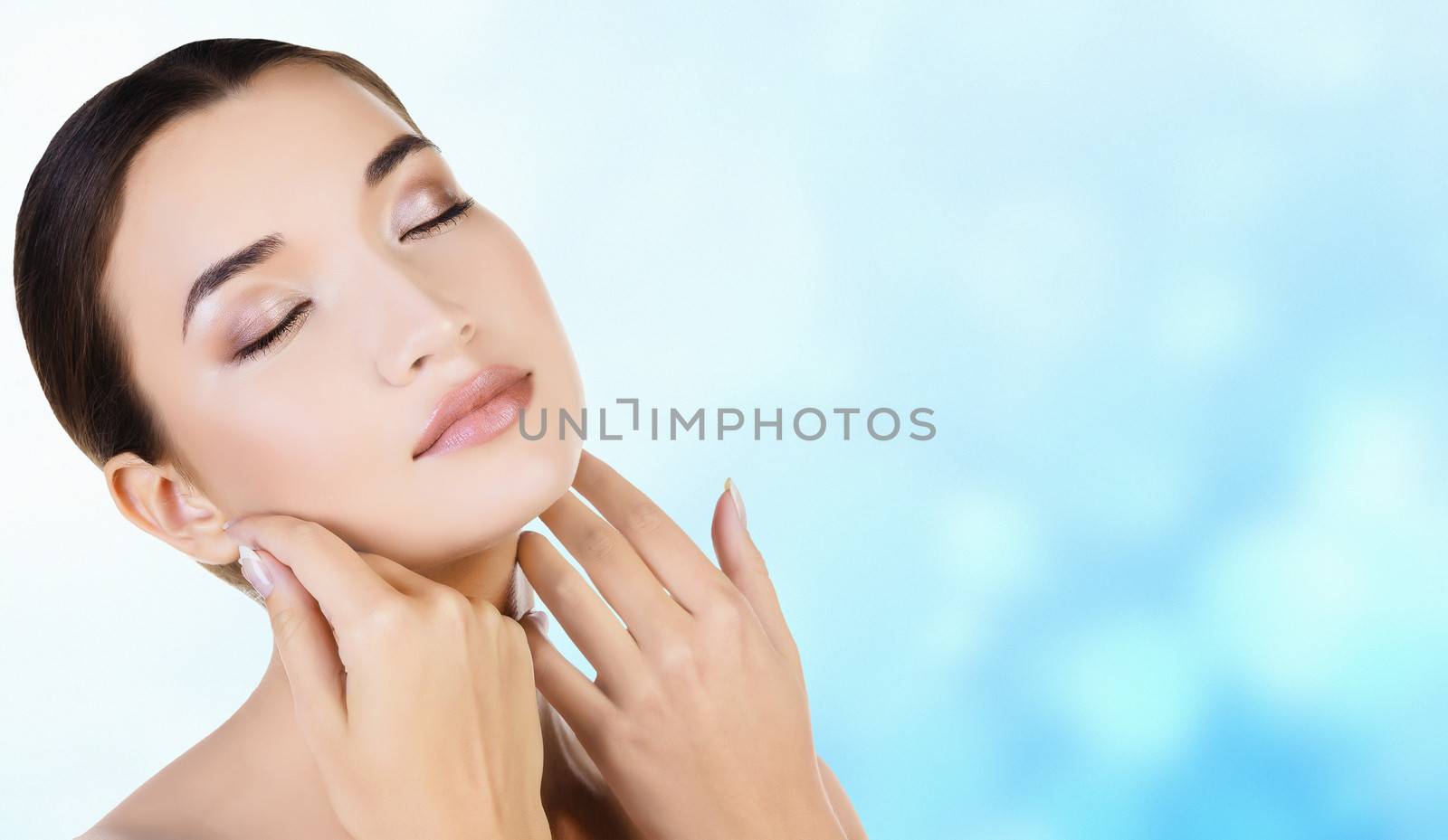 Asian girl with fresh skin on blue blurred background by Nobilior
