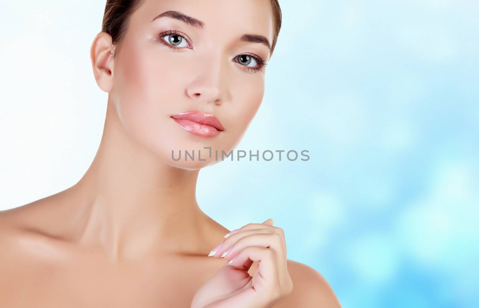 Asian girl with fresh skin on blue blurred background.