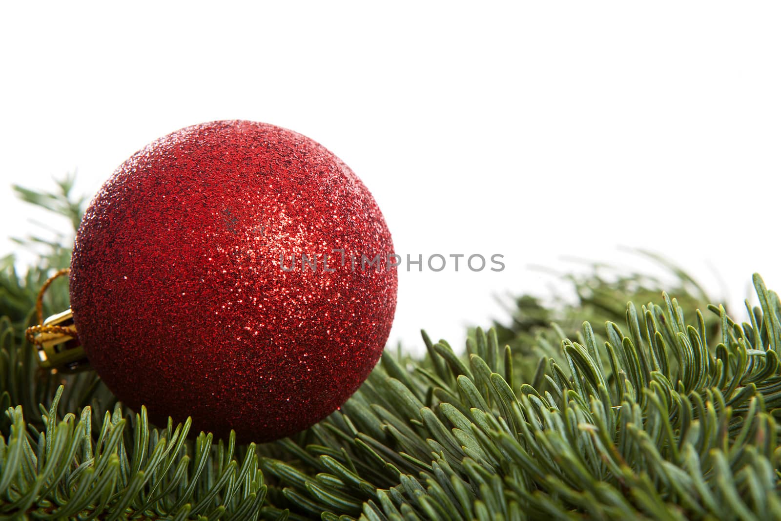 Red Christmas ball on pine tree over white background