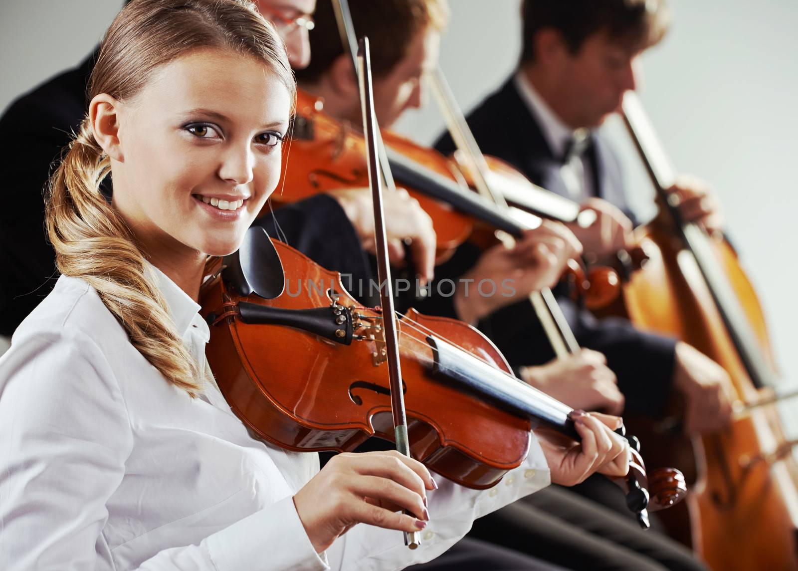  Musicians in concert, beautiful female violinist on foreground