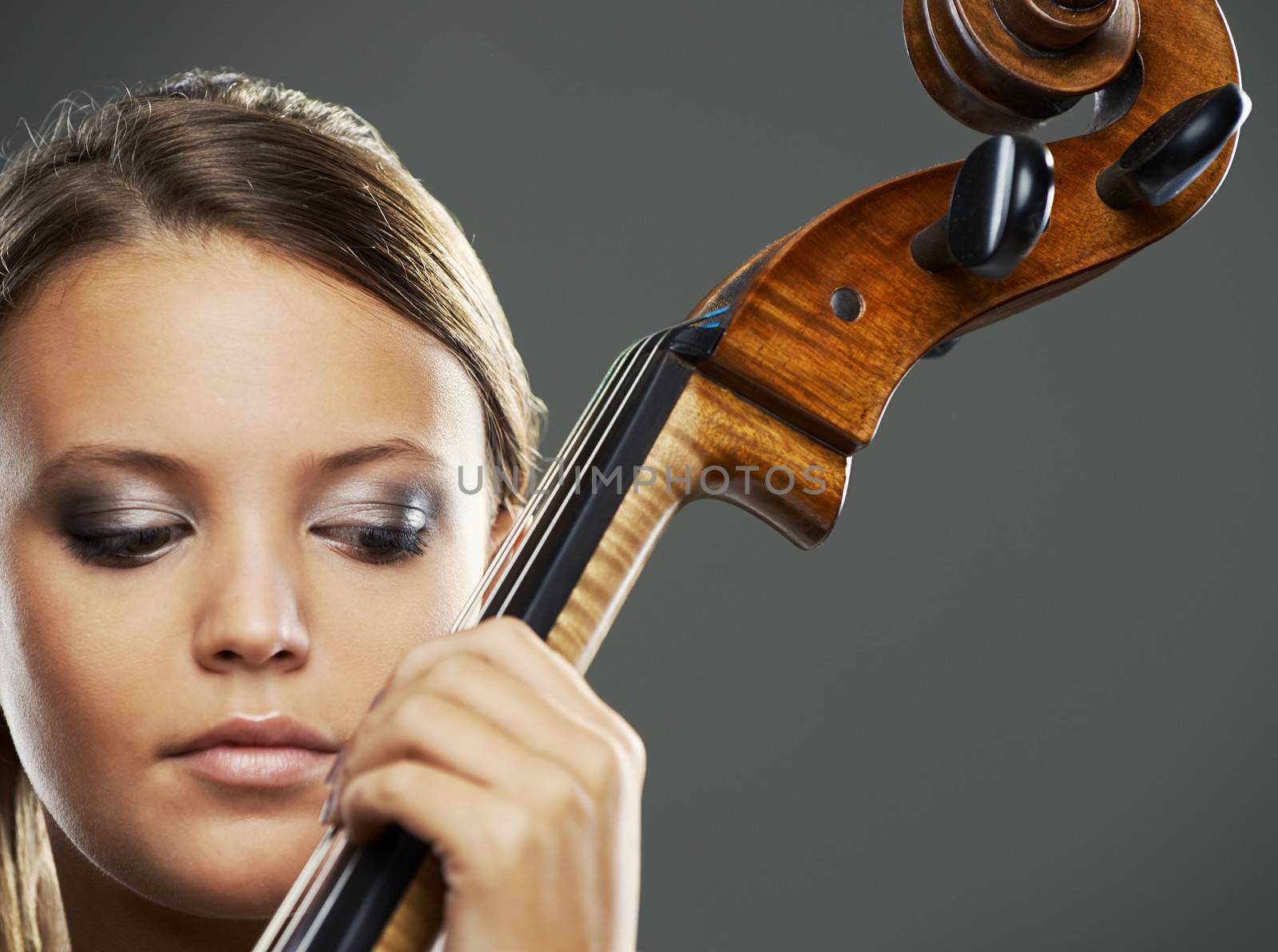 Close up portrait of a blond woman playing cello