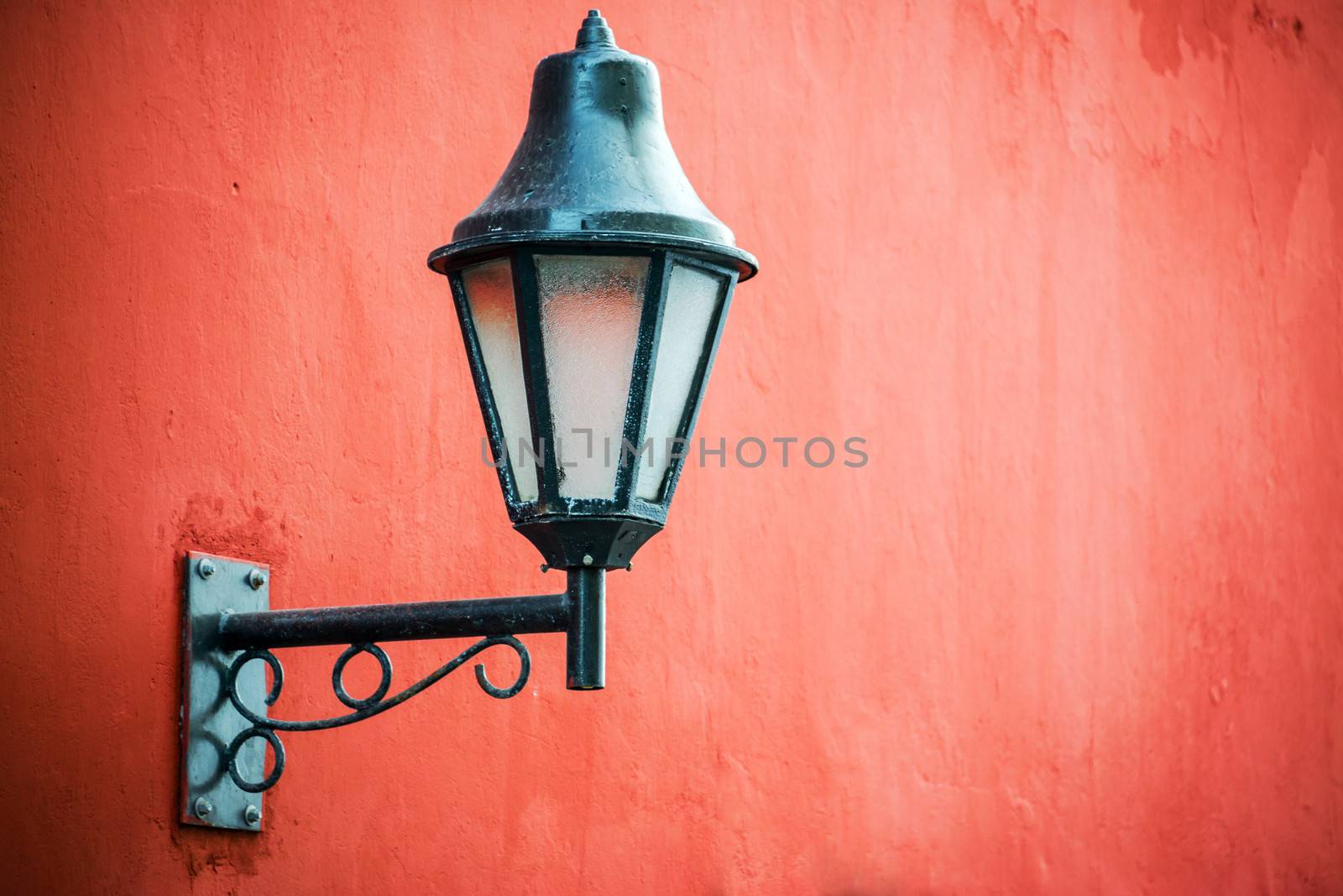 Historic colonial street light set against a vibrant red wall in Cartagena, Colombia