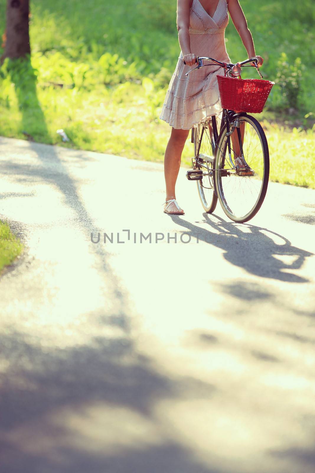 Cropped image of young woman with bicycle on a bicycle lane