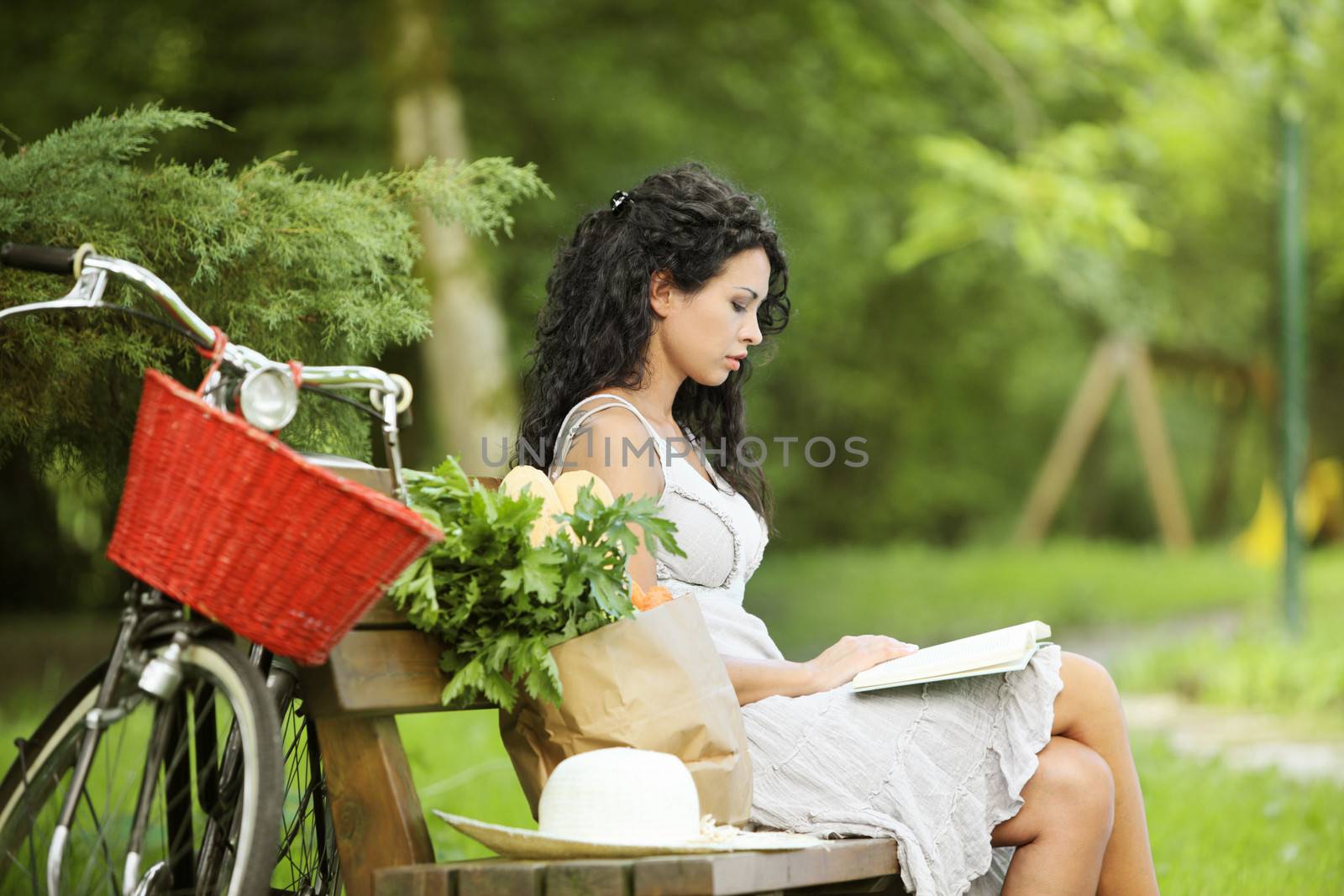 Young beautiful woman reading a book at a park