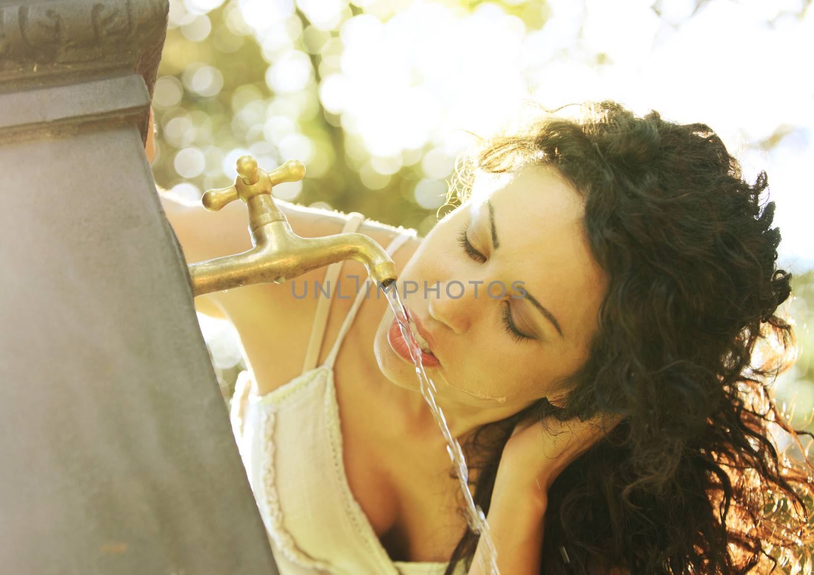 Young girl seeking refreshment from water fountain 