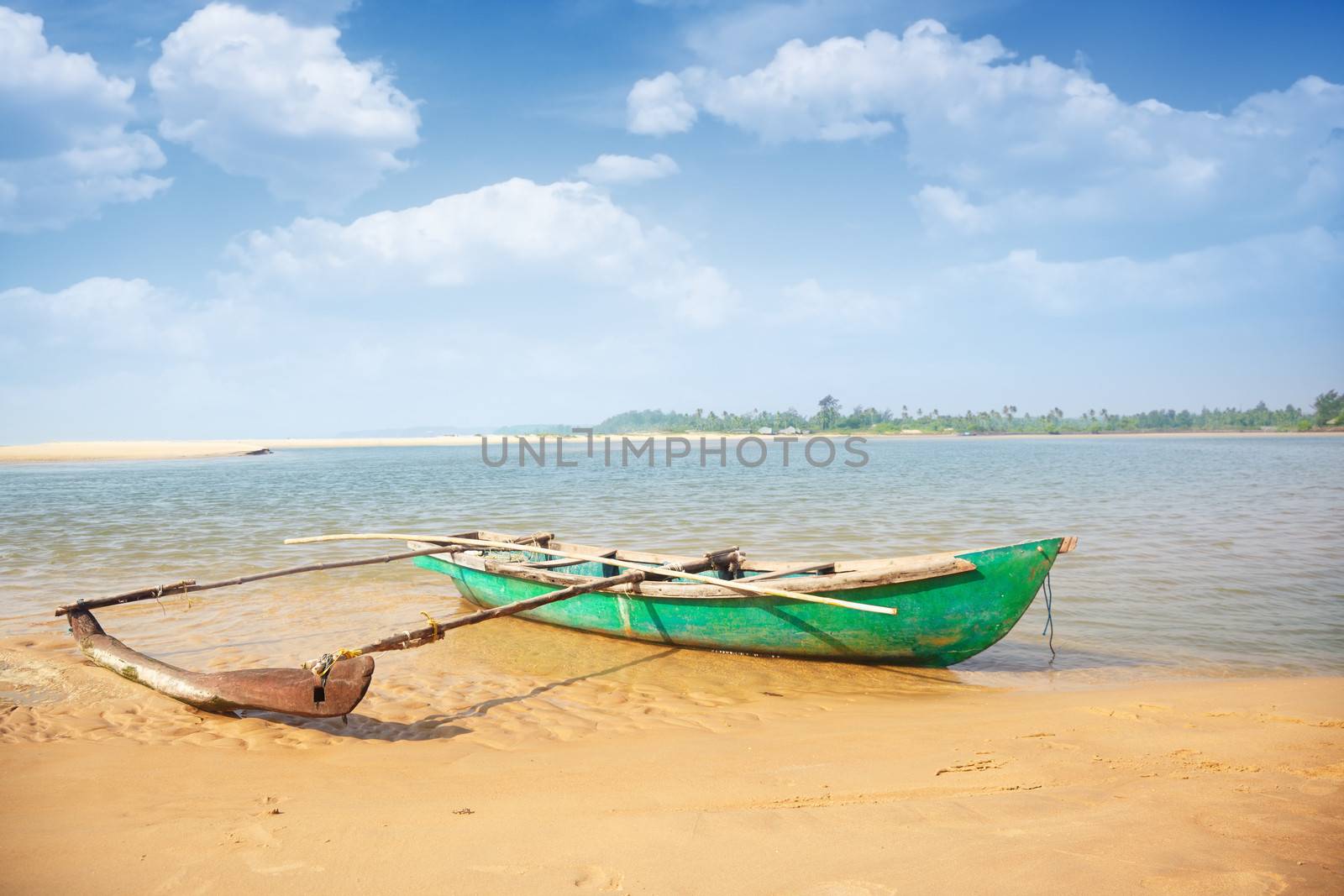 Old small boat at the tropical beach in India. Vibrant colors