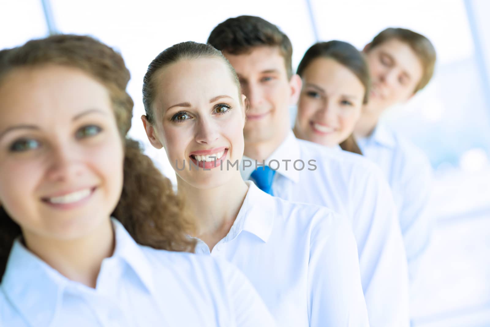 portrait of a young business woman standing in line with colleagues, concept of teamwork