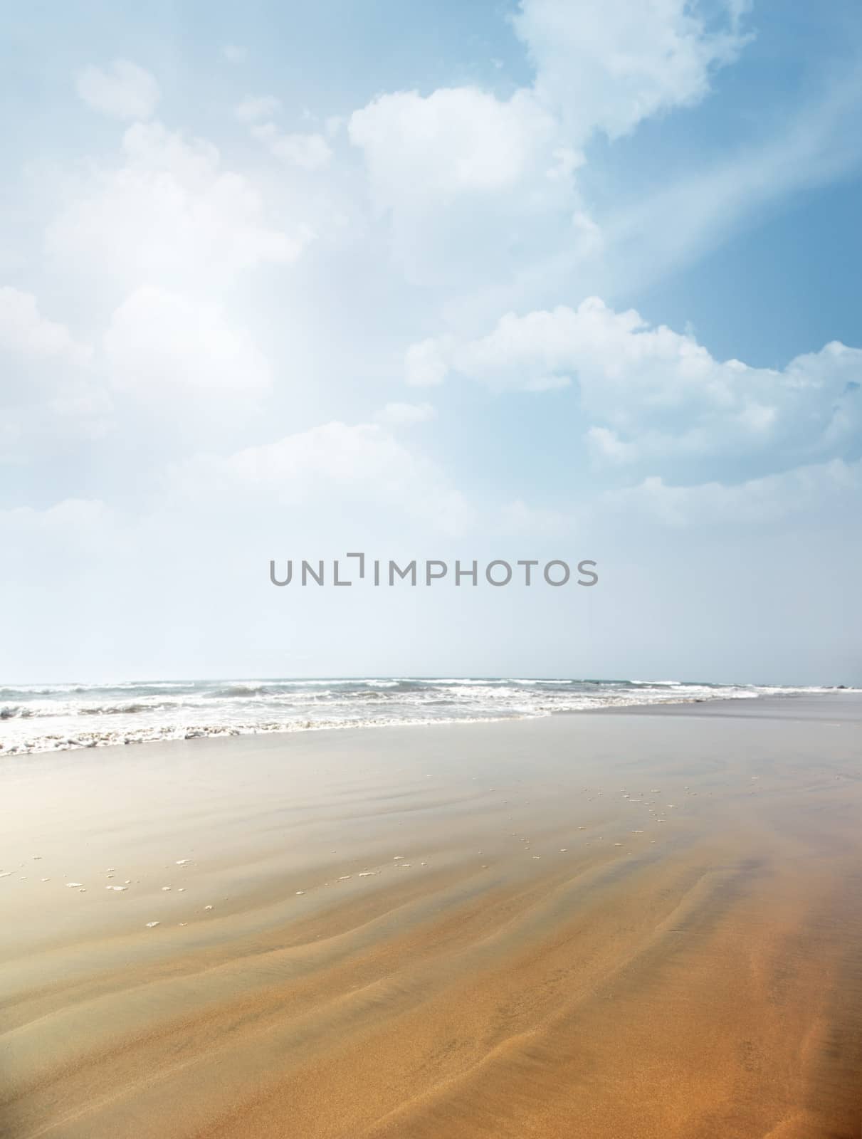 Vertical photo of the summer beach with rippled sand. Vibrant colors