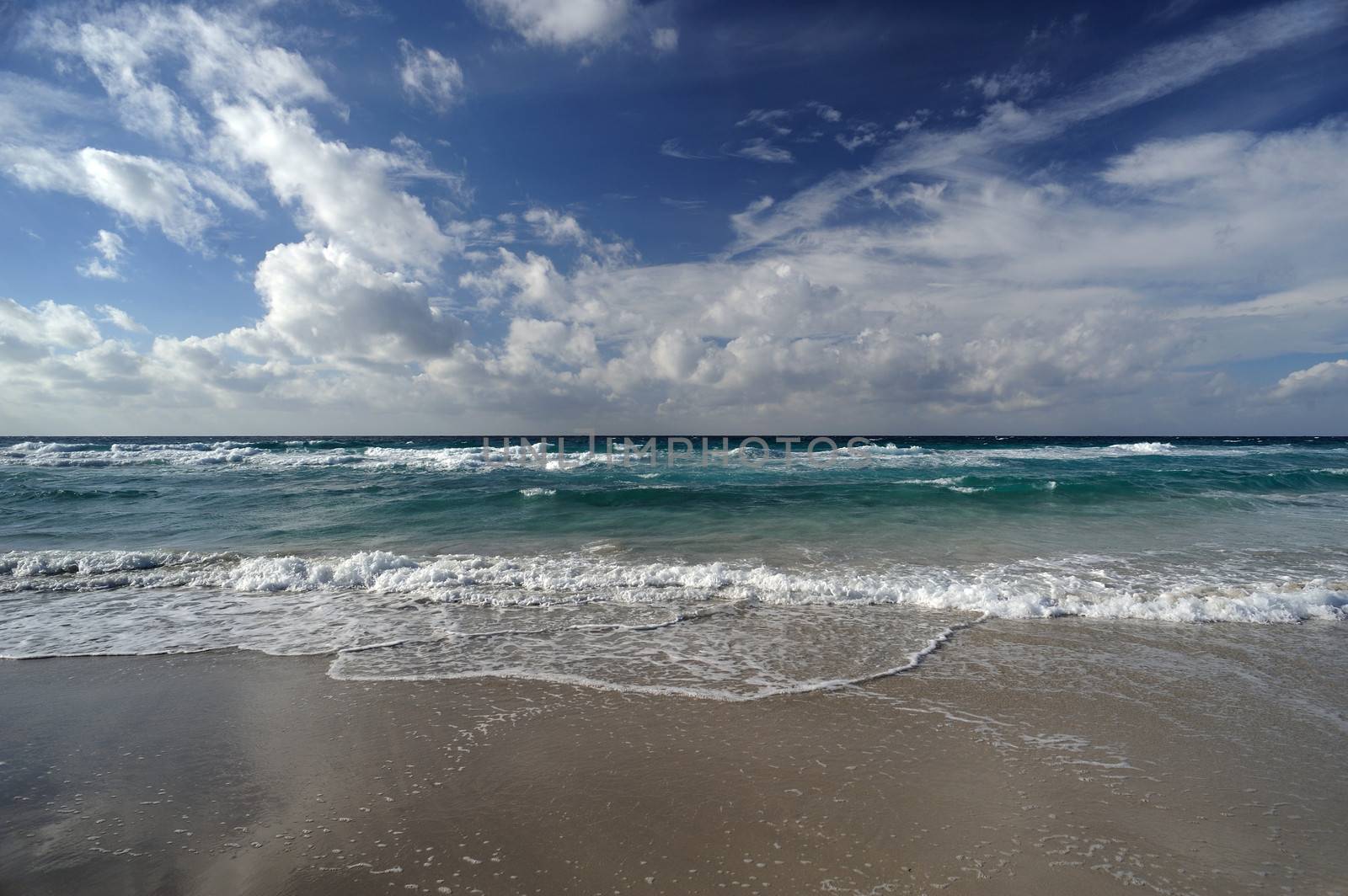 Landscape with sea and sand, white clouds in the sky