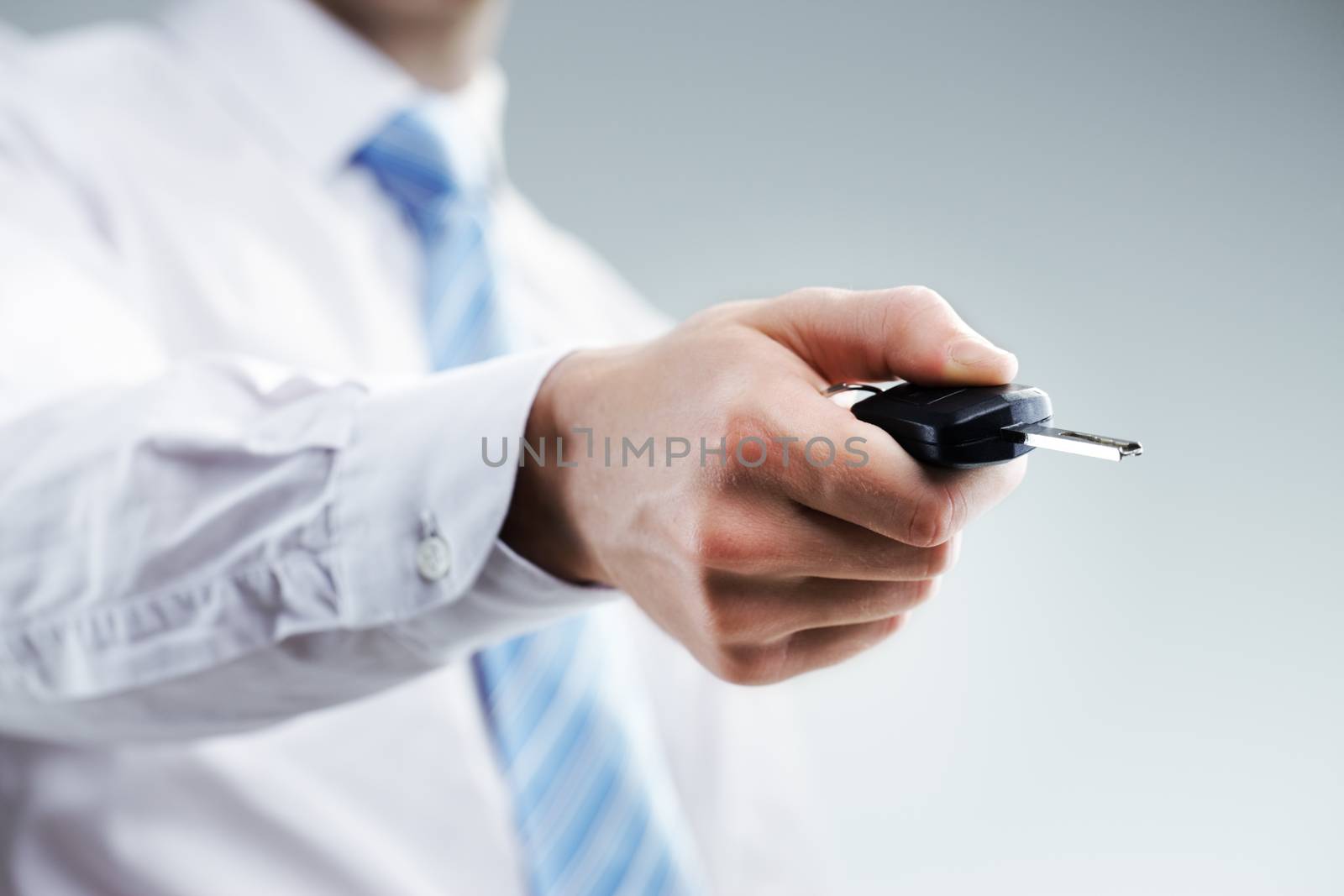 Businessman's hand unlocking his car with key car